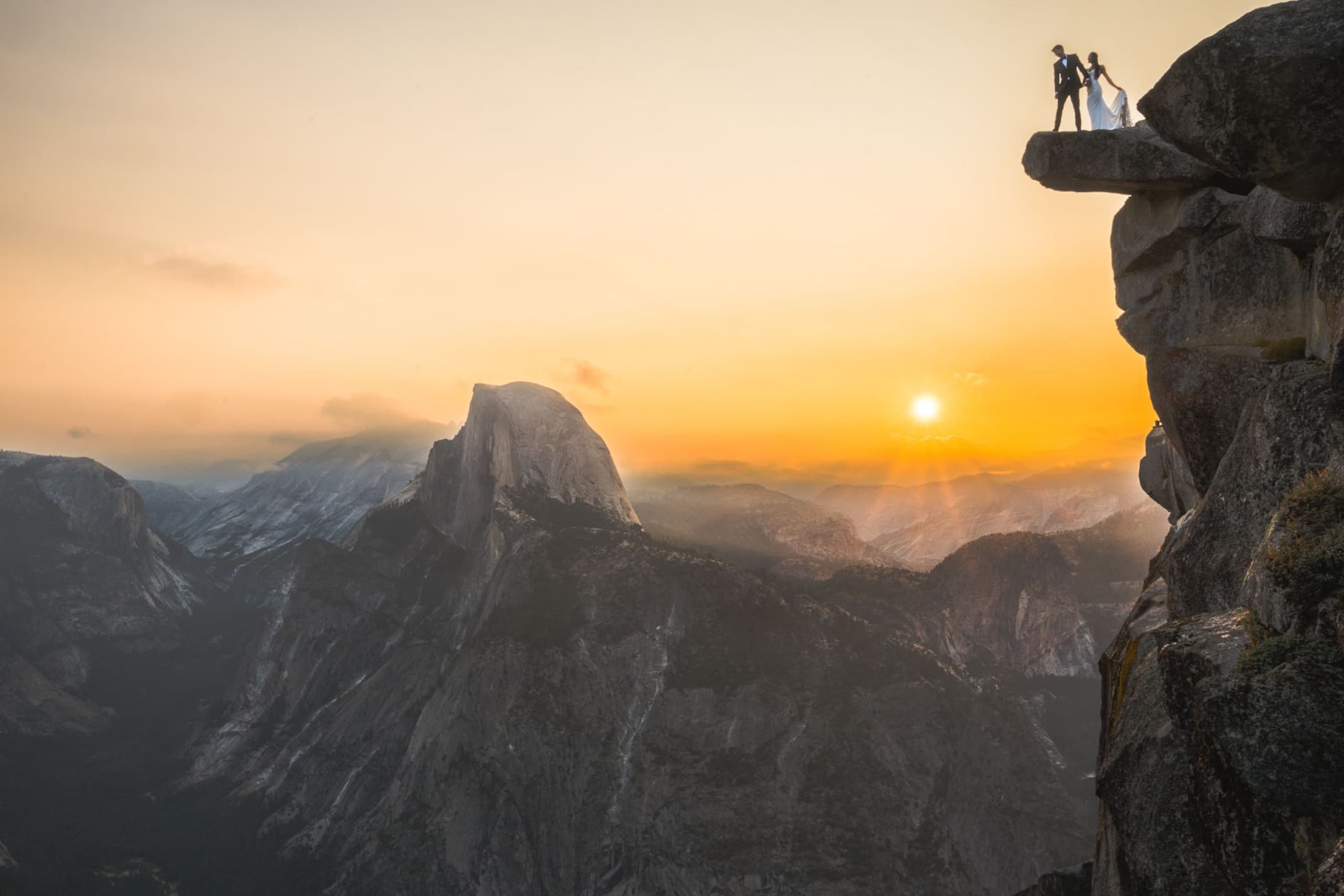 Silhouetted wedding couple on Glacier Point with Half Dome and a fiery Yosemite sunset behind them