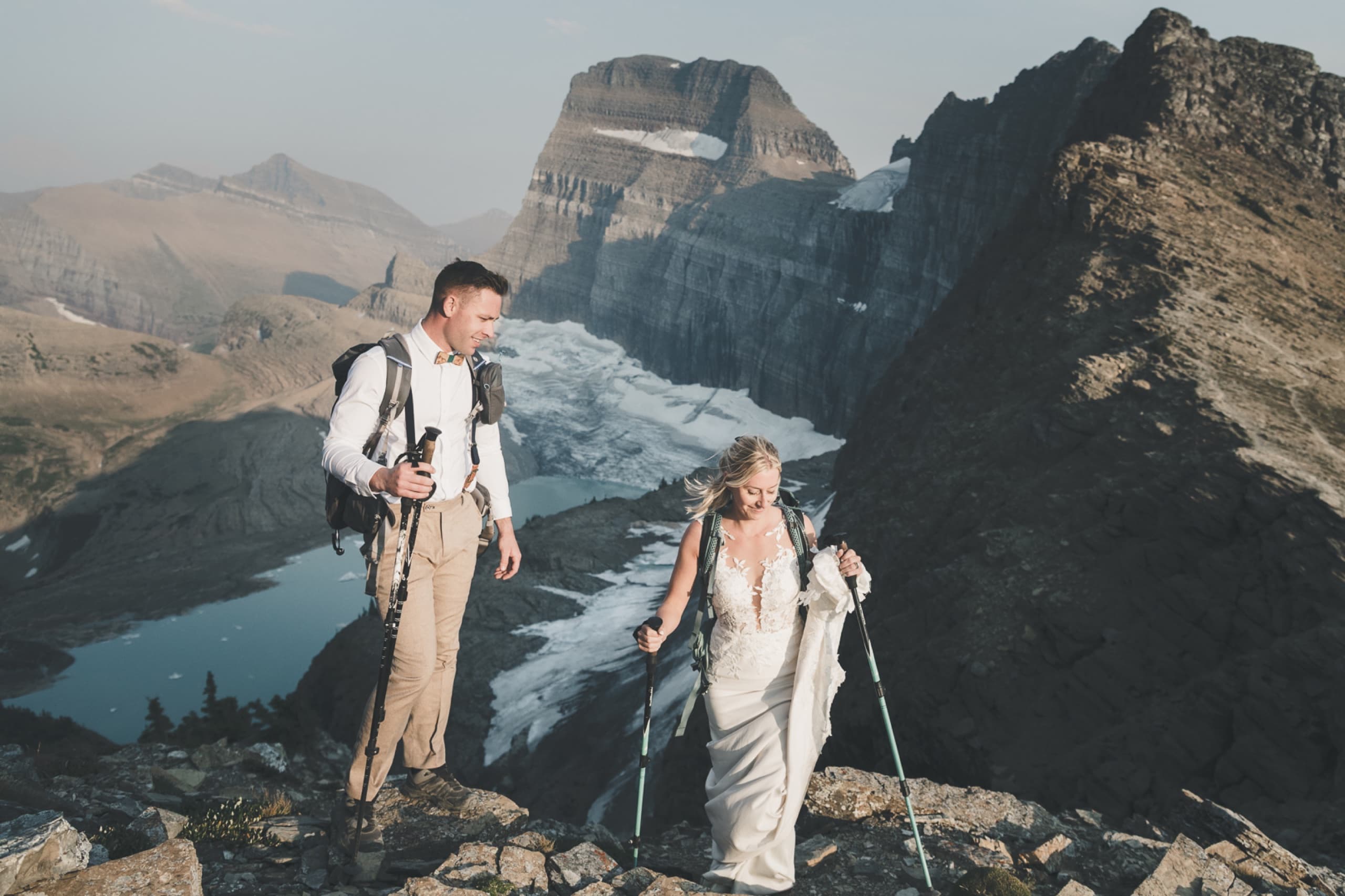 Couple with backpacks on a rocky ridge high above the valley
