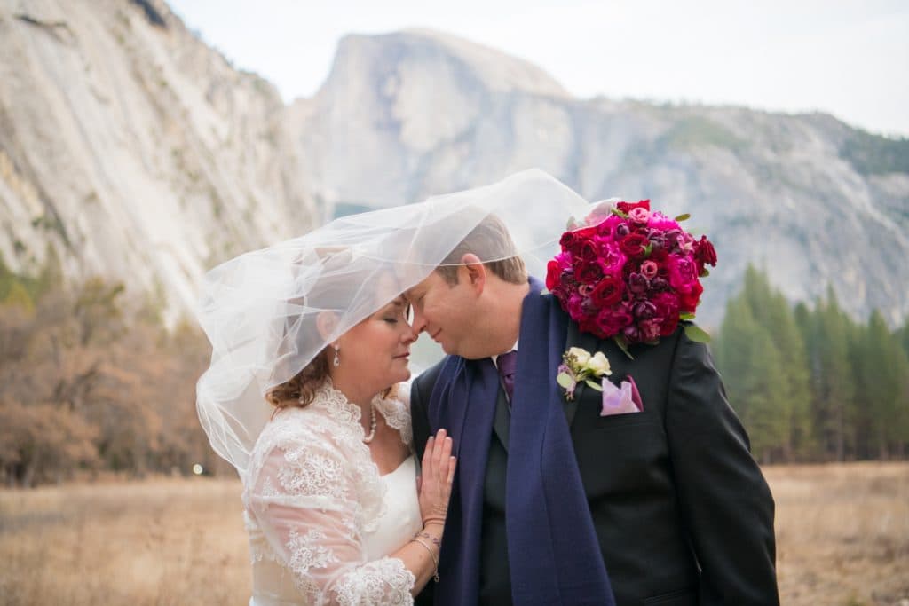 Winter Yosemite elopement couple with snow-covered granite and frozen waterfalls