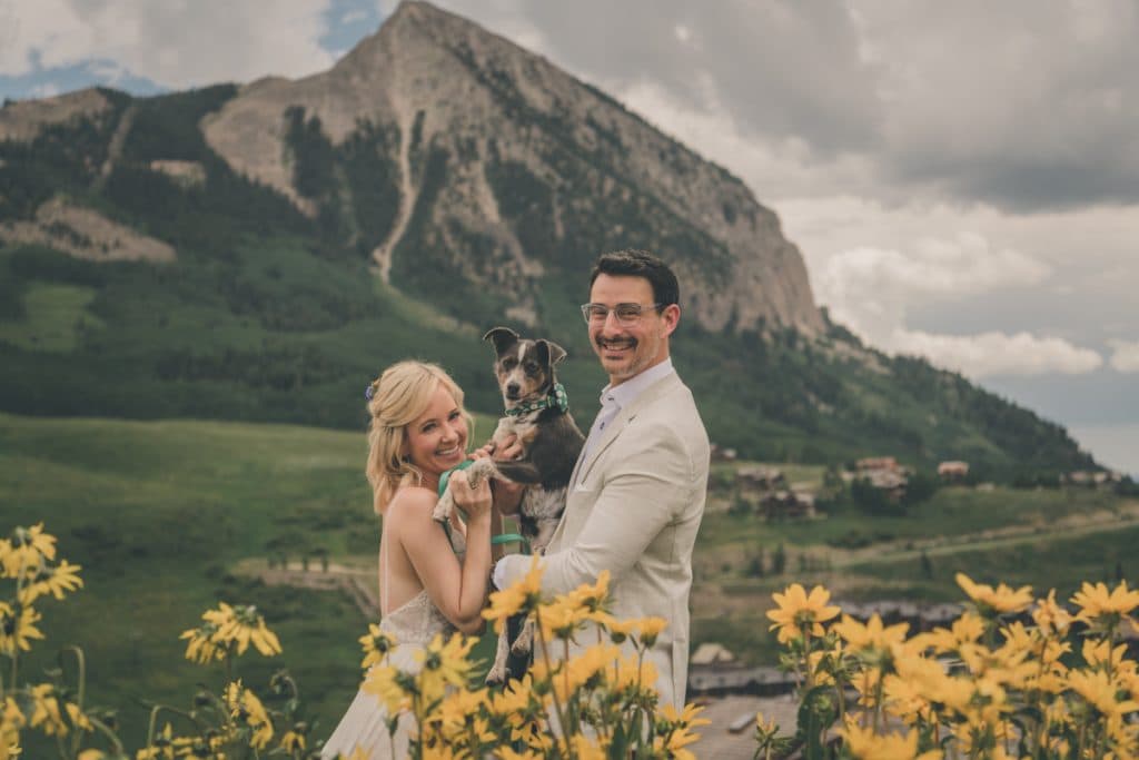 Crested Butte elopement couple on mountain trail with wildflowers and peaks