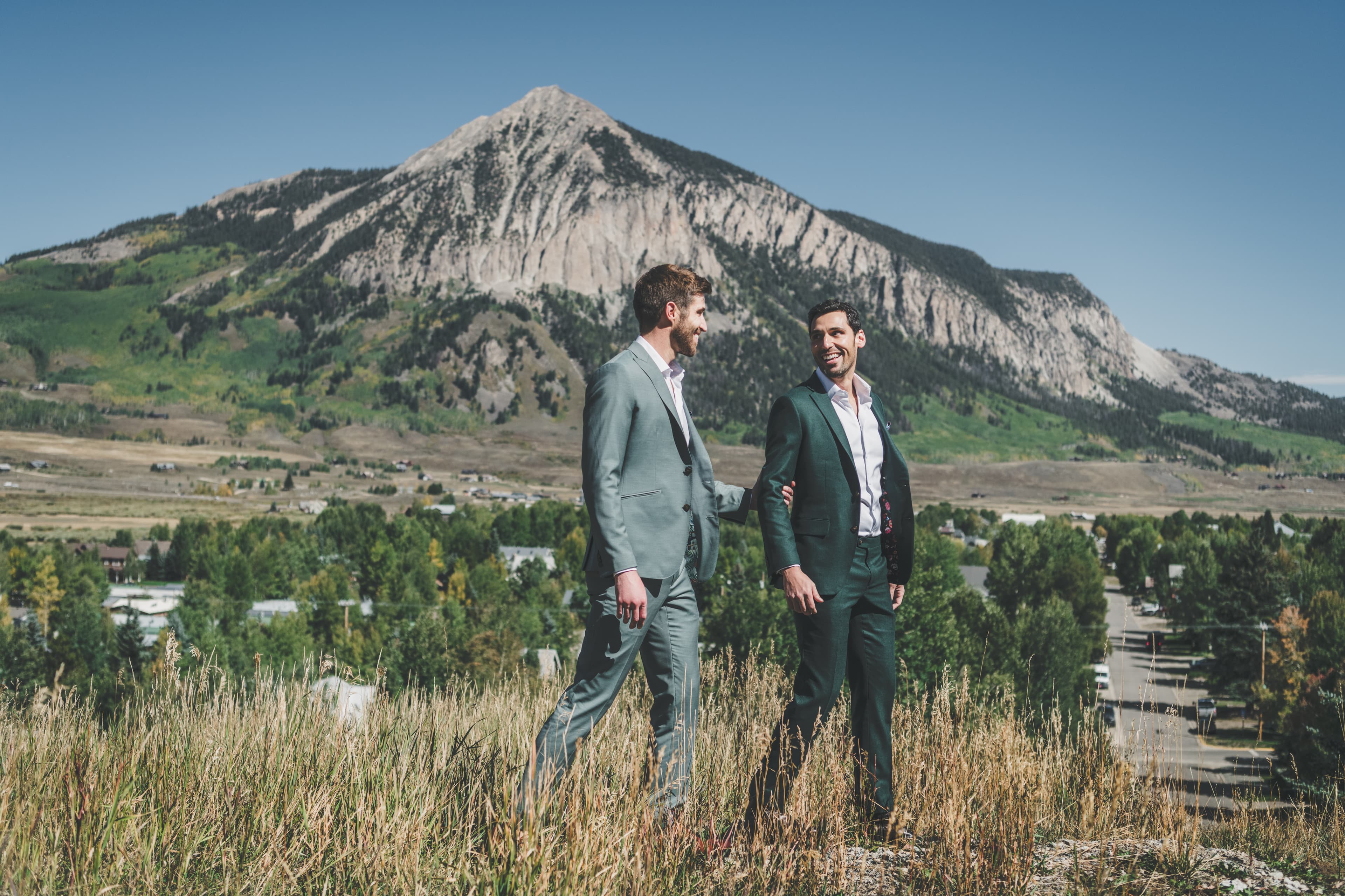 Greg and John laughing together with Mt. Crested Butte and the town in the valley behind them