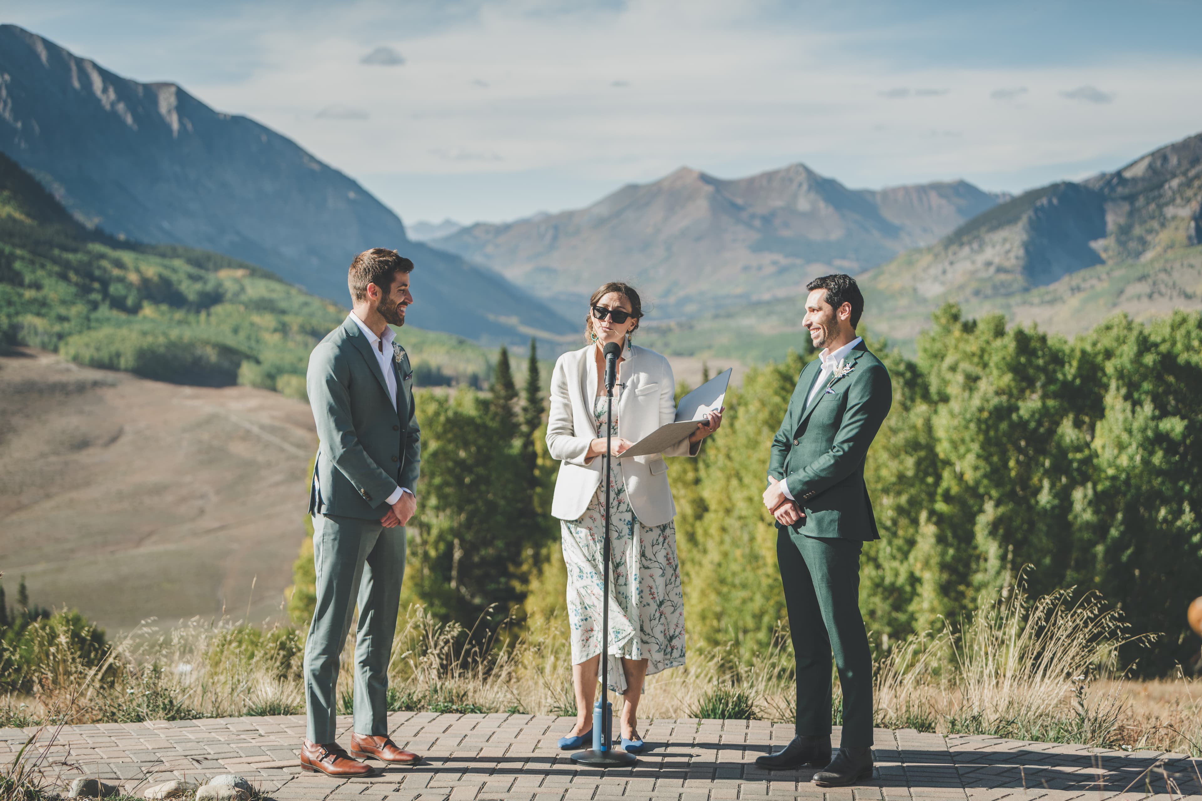 Greg and John exchange vows with their officiant at Ten Peaks, Elk Mountains rolling into the distance
