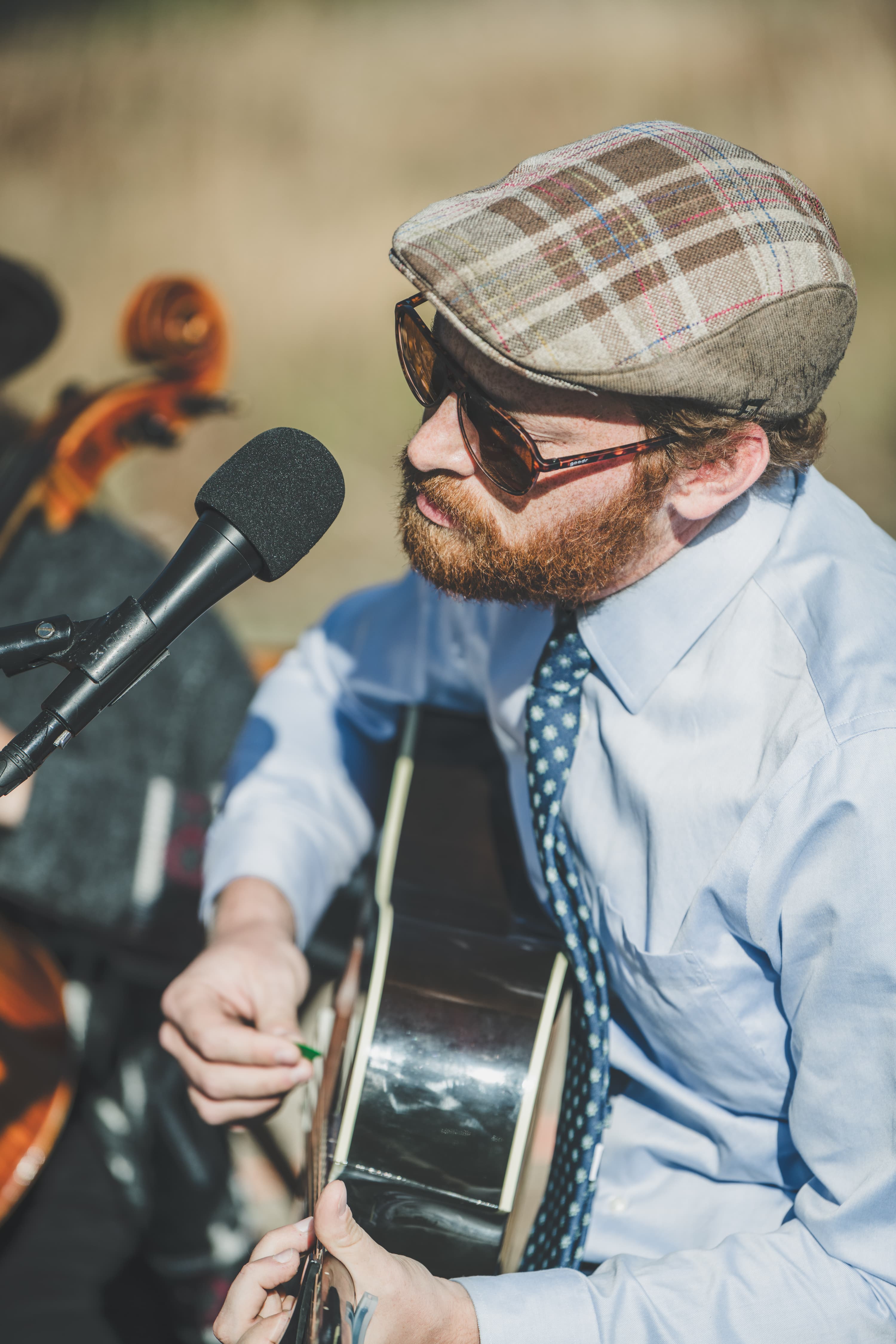 Musician with banjo and acoustic guitar performs during Greg and John's outdoor ceremony