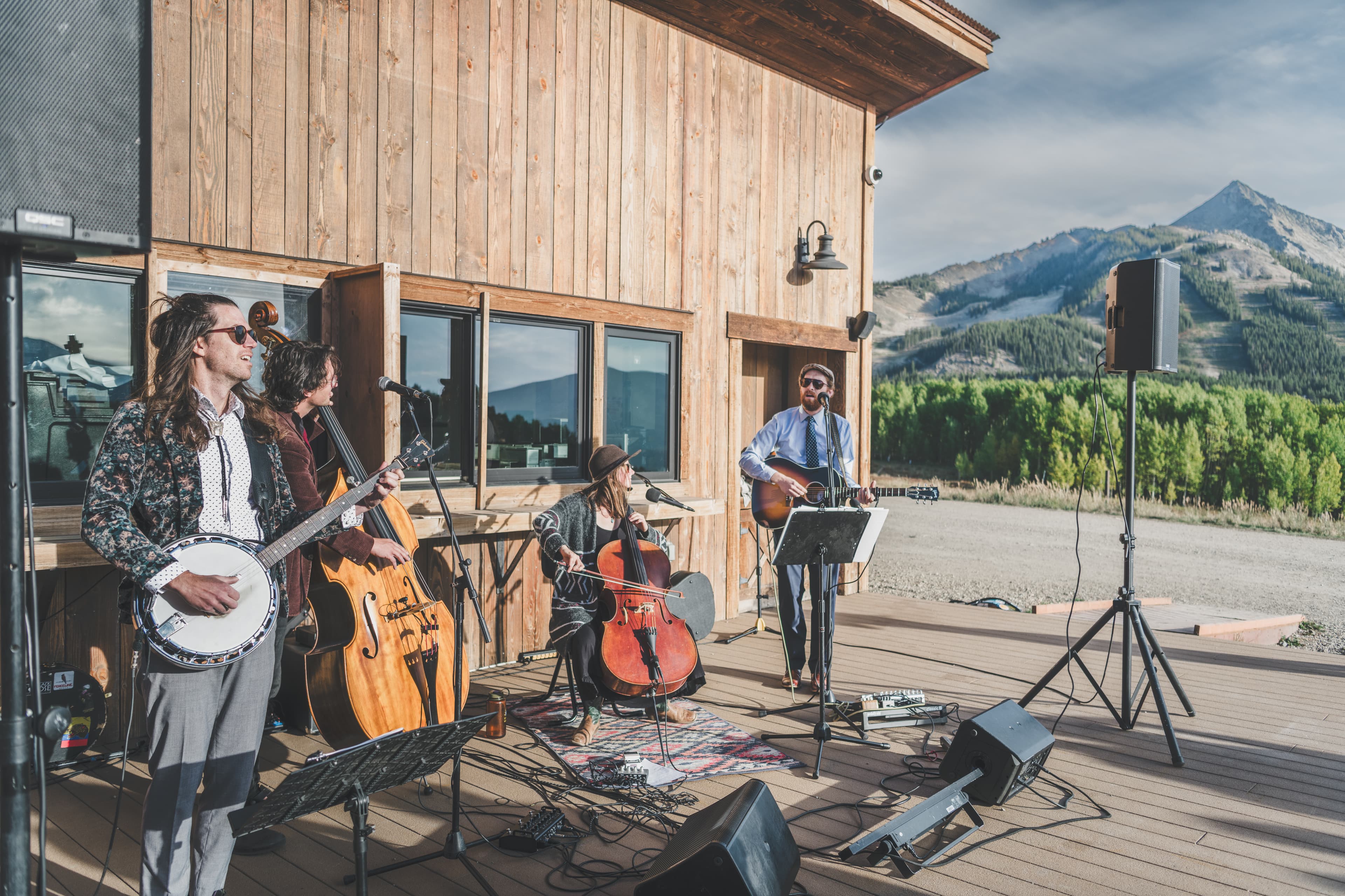 Bluegrass band performs on the wooden outdoor deck at Ten Peaks with Mt. Crested Butte behind
