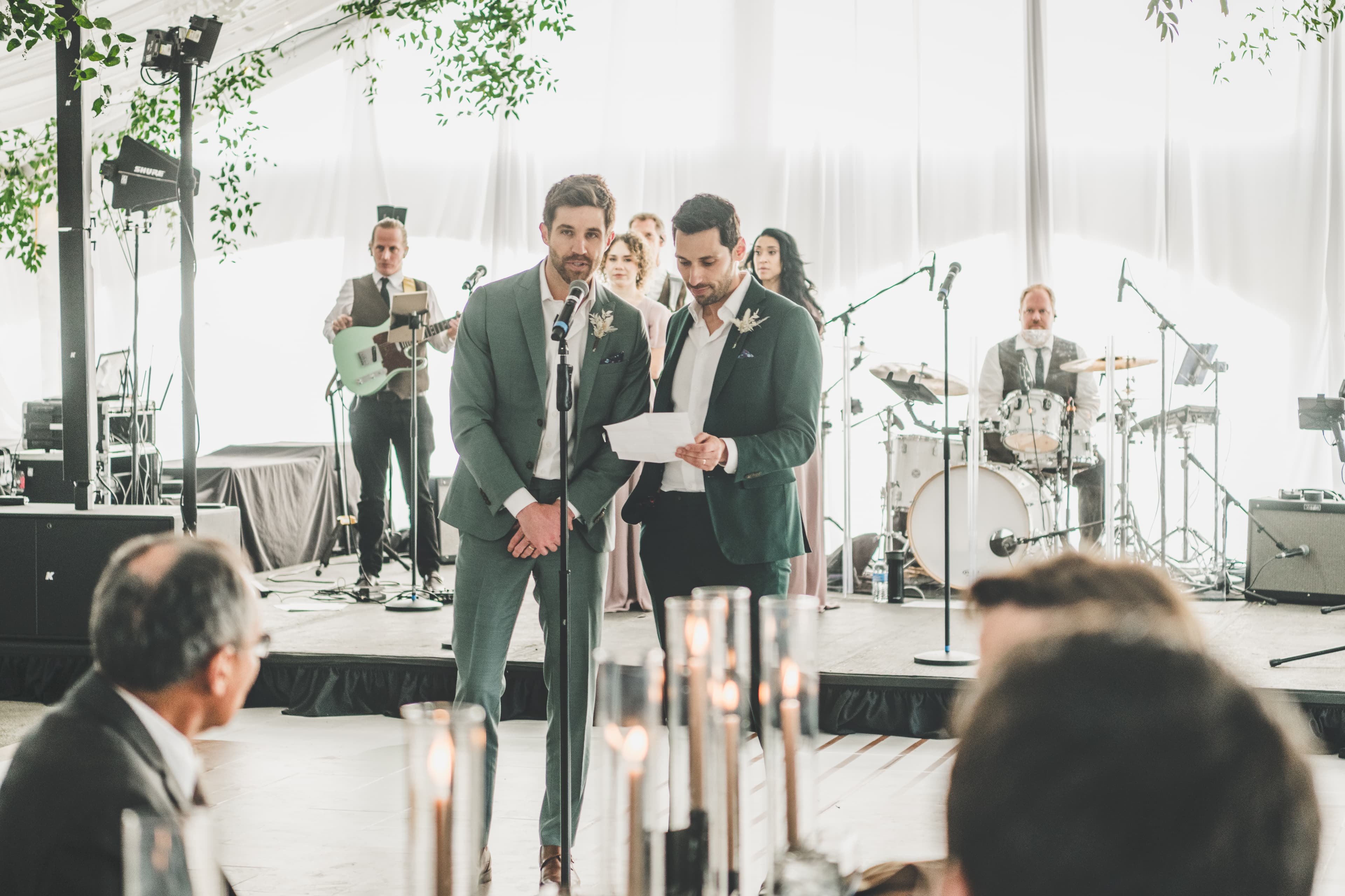 Greg and John give a toast on stage during their reception with their bluegrass band behind them