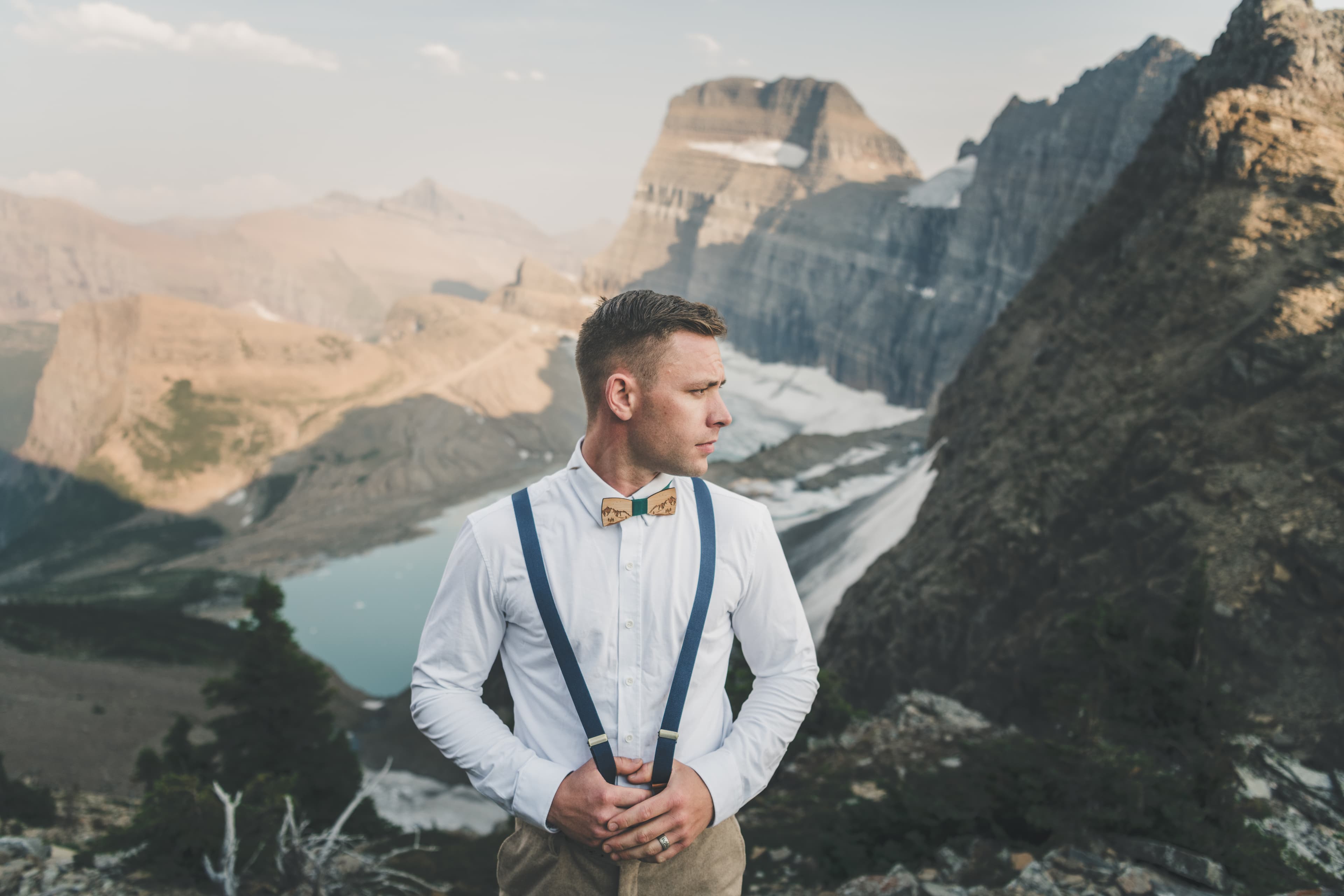 Ryan in suspenders and bow tie with Grinnell Glacier and Mount Gould rising behind him
