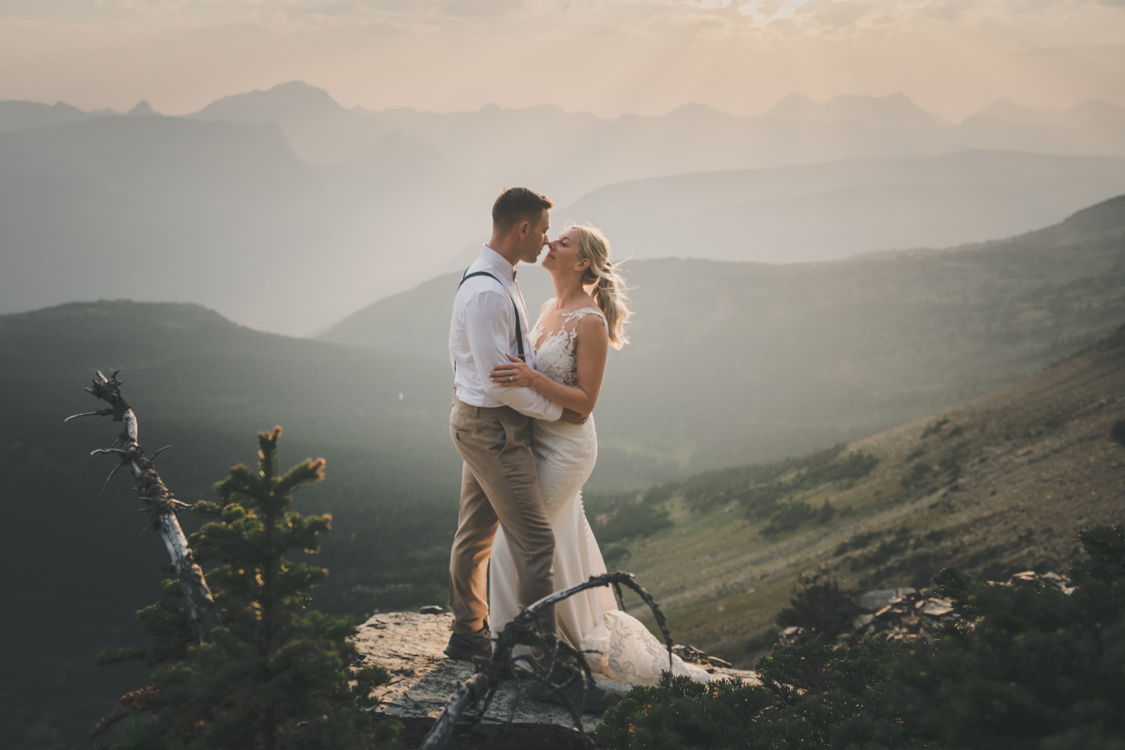 Intimate sunset kiss between Shawna and Ryan high above Glacier National Park's ridges