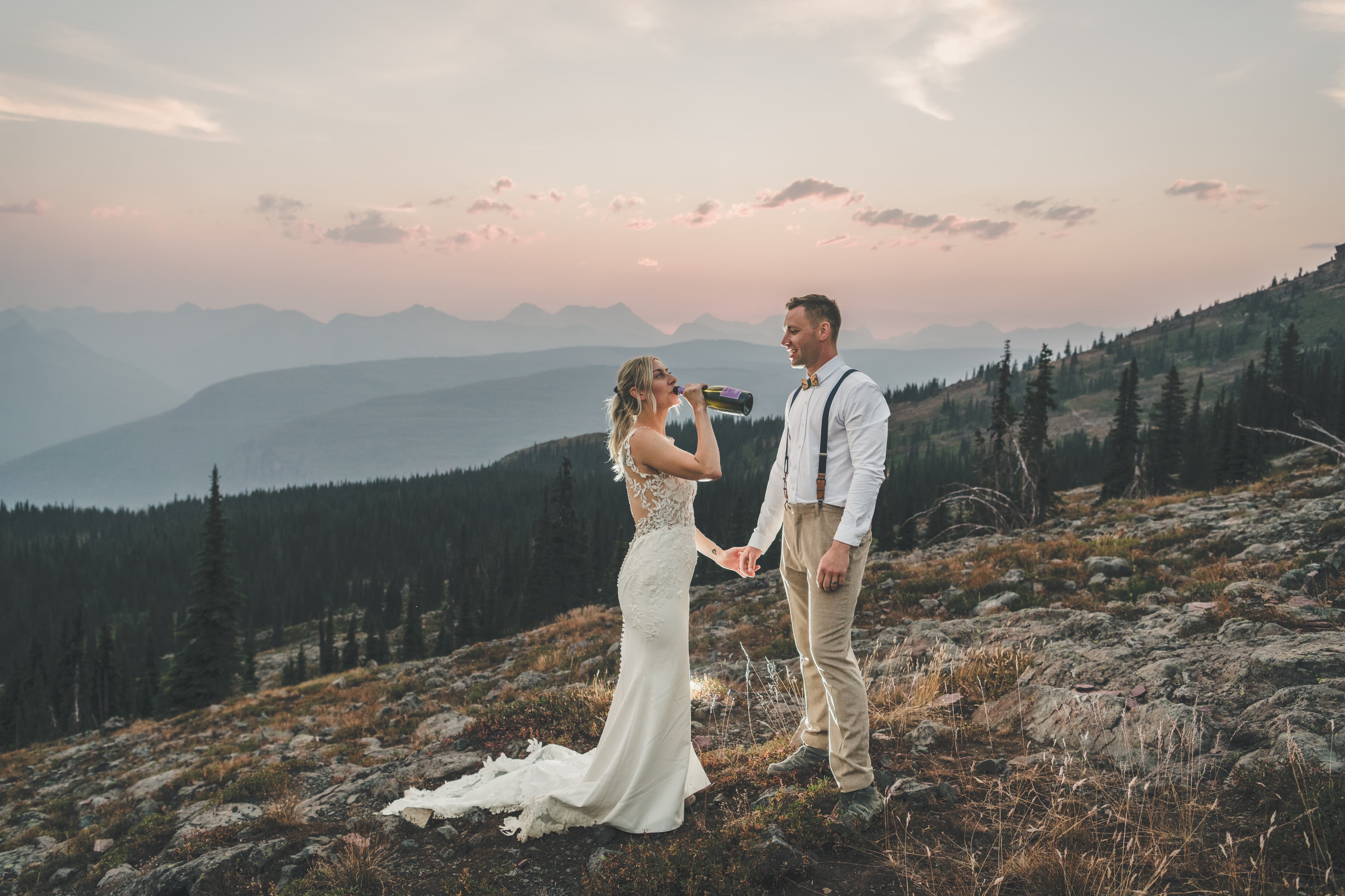 Shawna and Ryan walking hand-in-hand up an alpine meadow above tree line in Glacier National Park