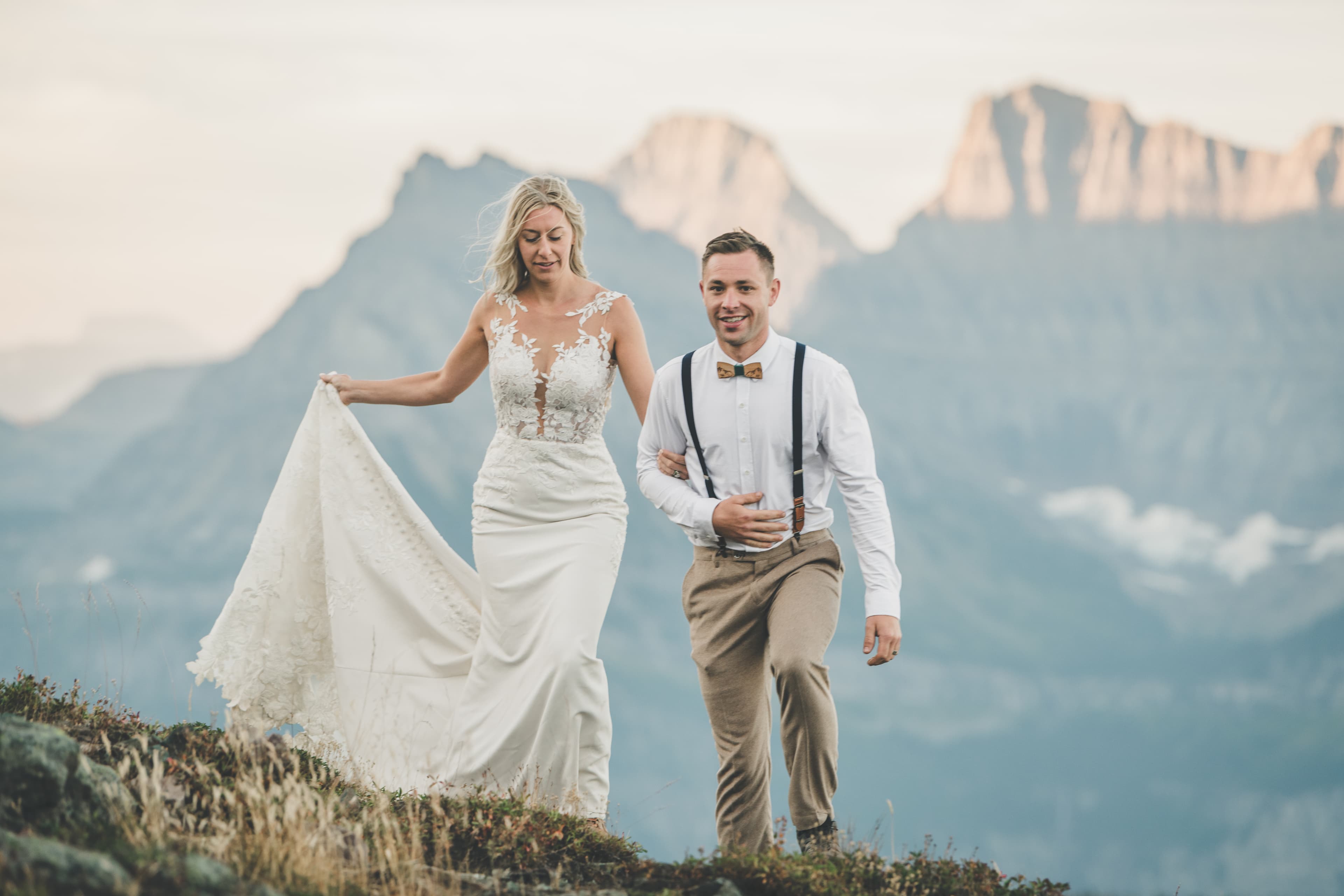 Shawna and Ryan walking the alpine ridge as sunset light catches the cliffs behind them
