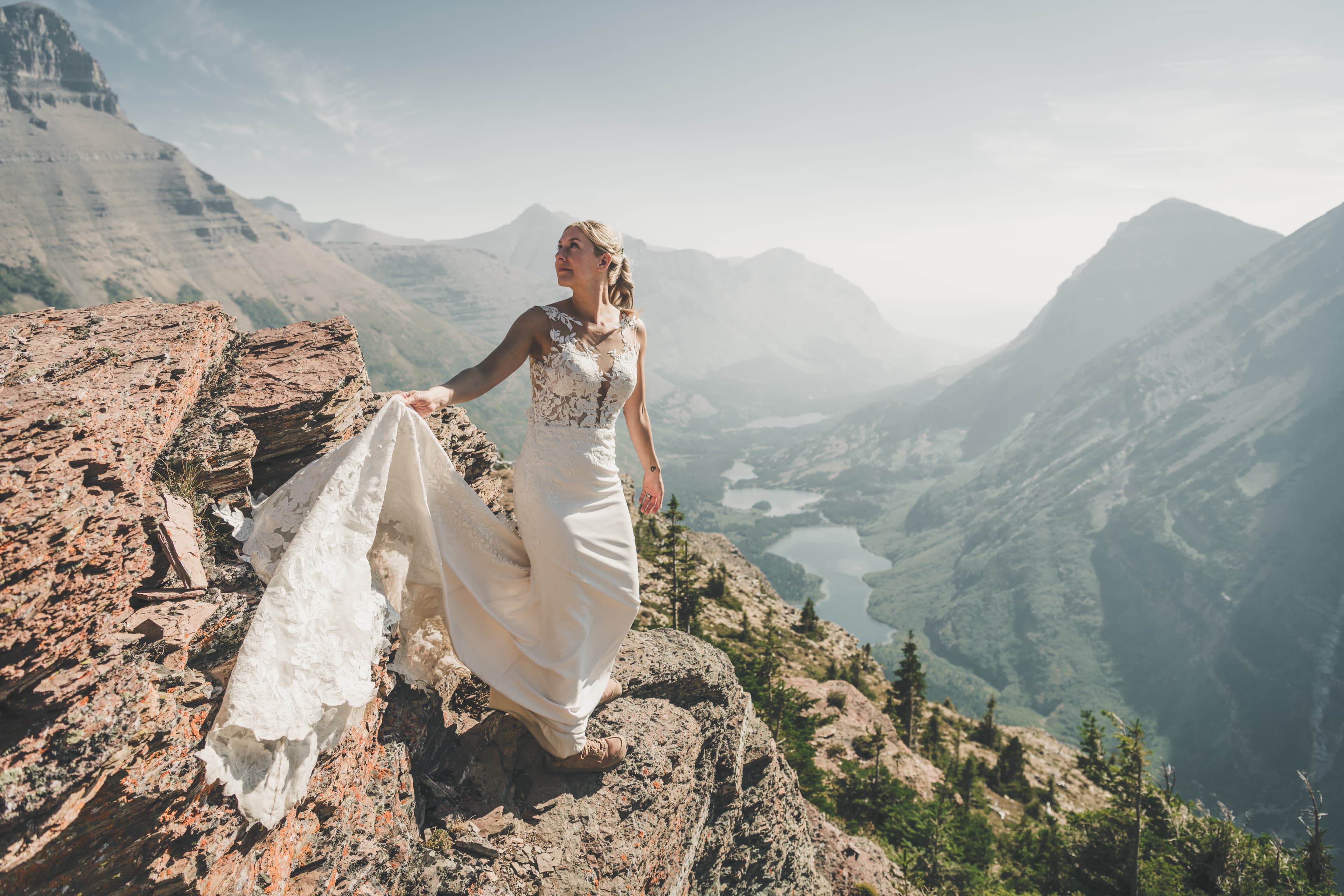Shawna alone at the edge of the cliff with her dress flowing toward the Many Glacier valley