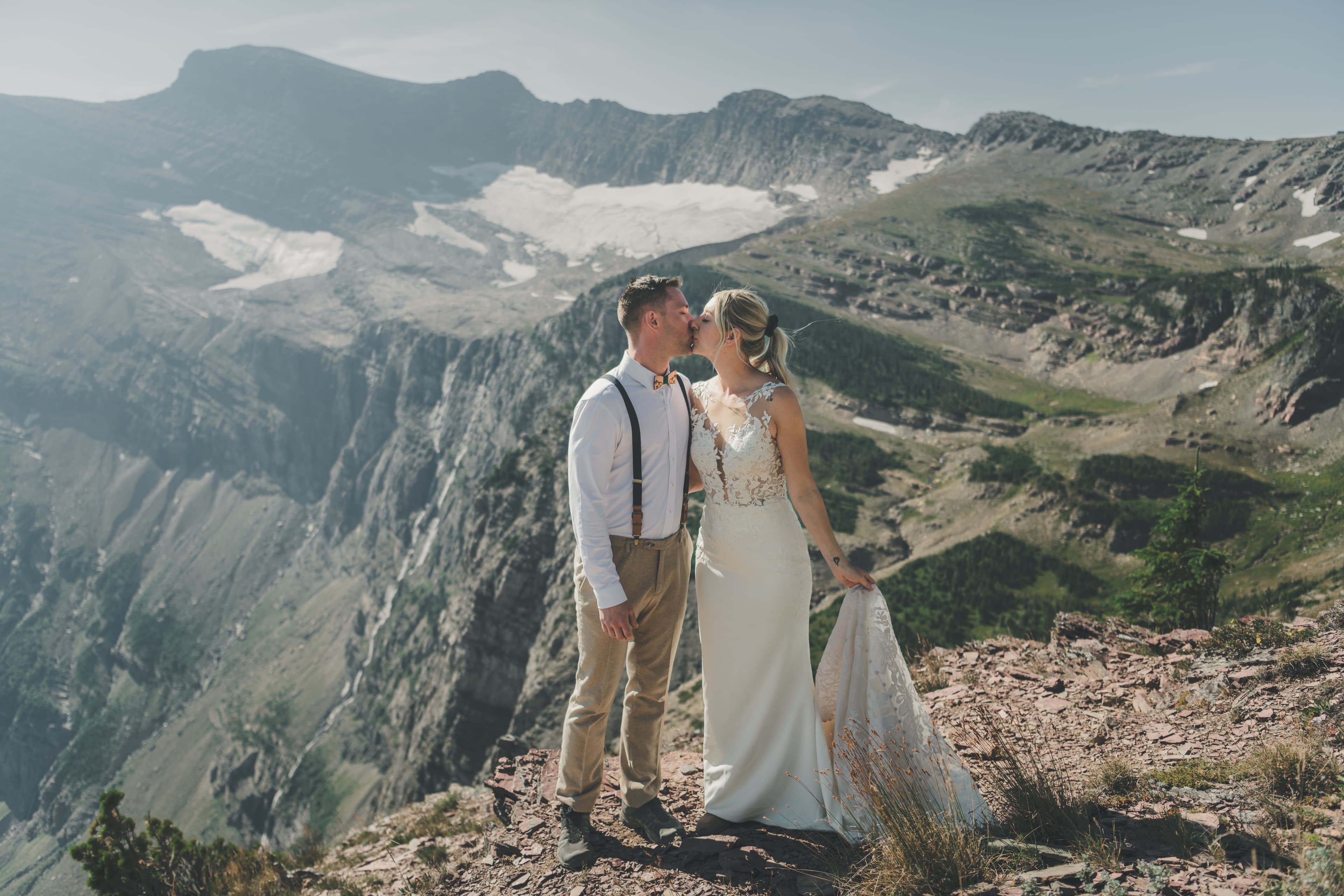 Shawna and Ryan kissing on a rocky outcrop with the Grinnell cirque and hanging snowfields behind them