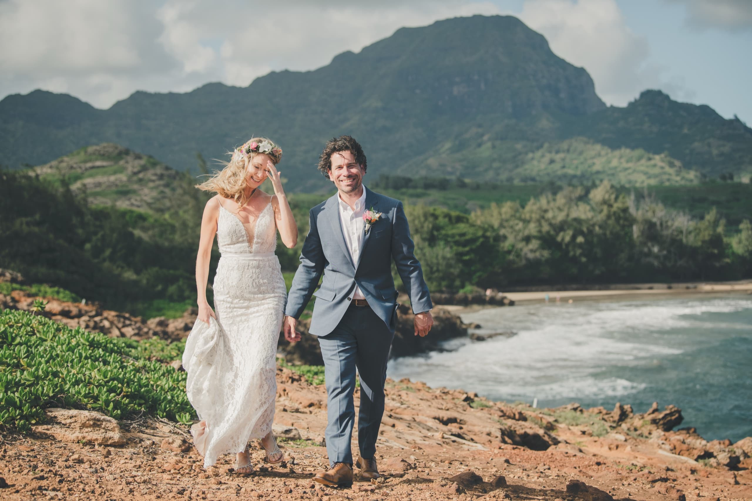 Erin and Kenny walking the wild Mahaulepu coast on Kauai's south shore with Hāʻupu Ridge behind them