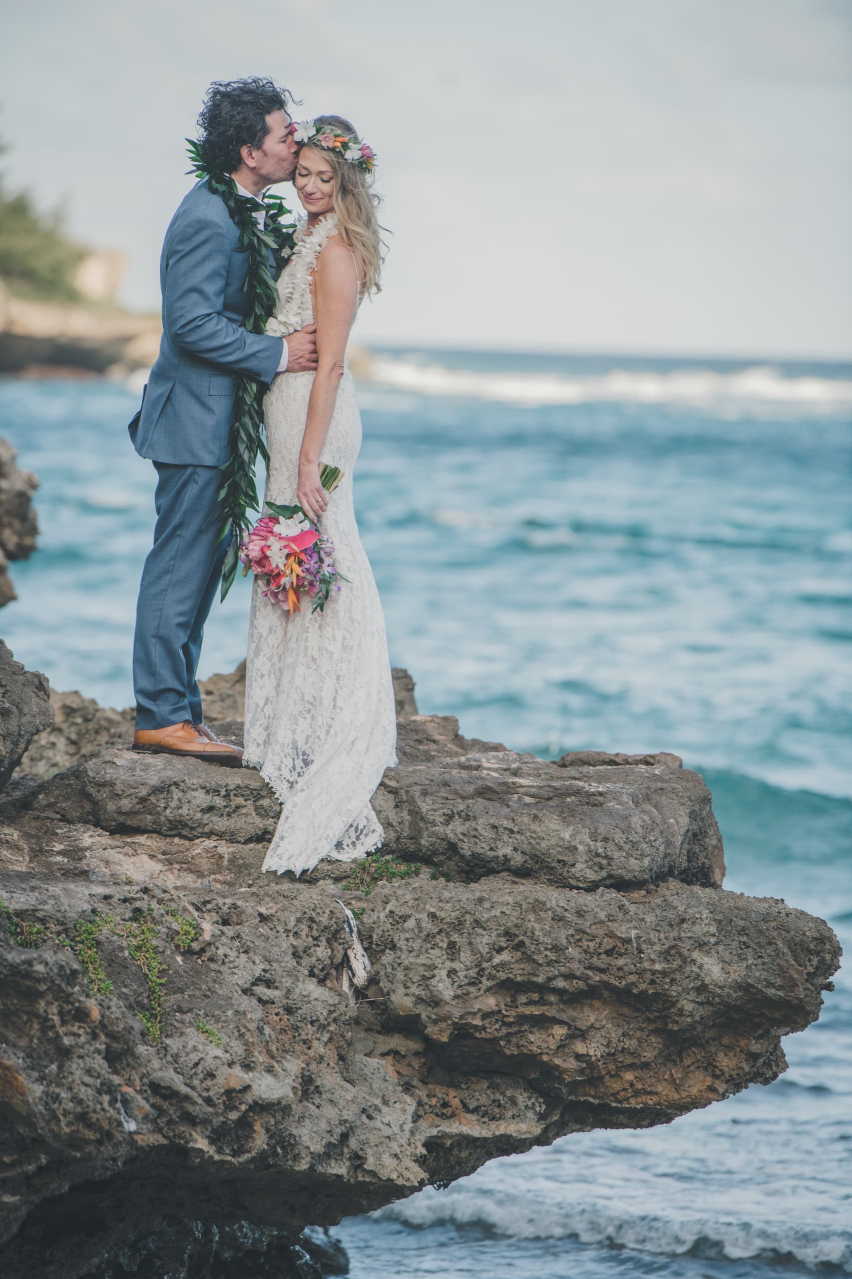 Kenny pulls Erin in for a quiet kiss on a sandstone cliff above the Pacific
