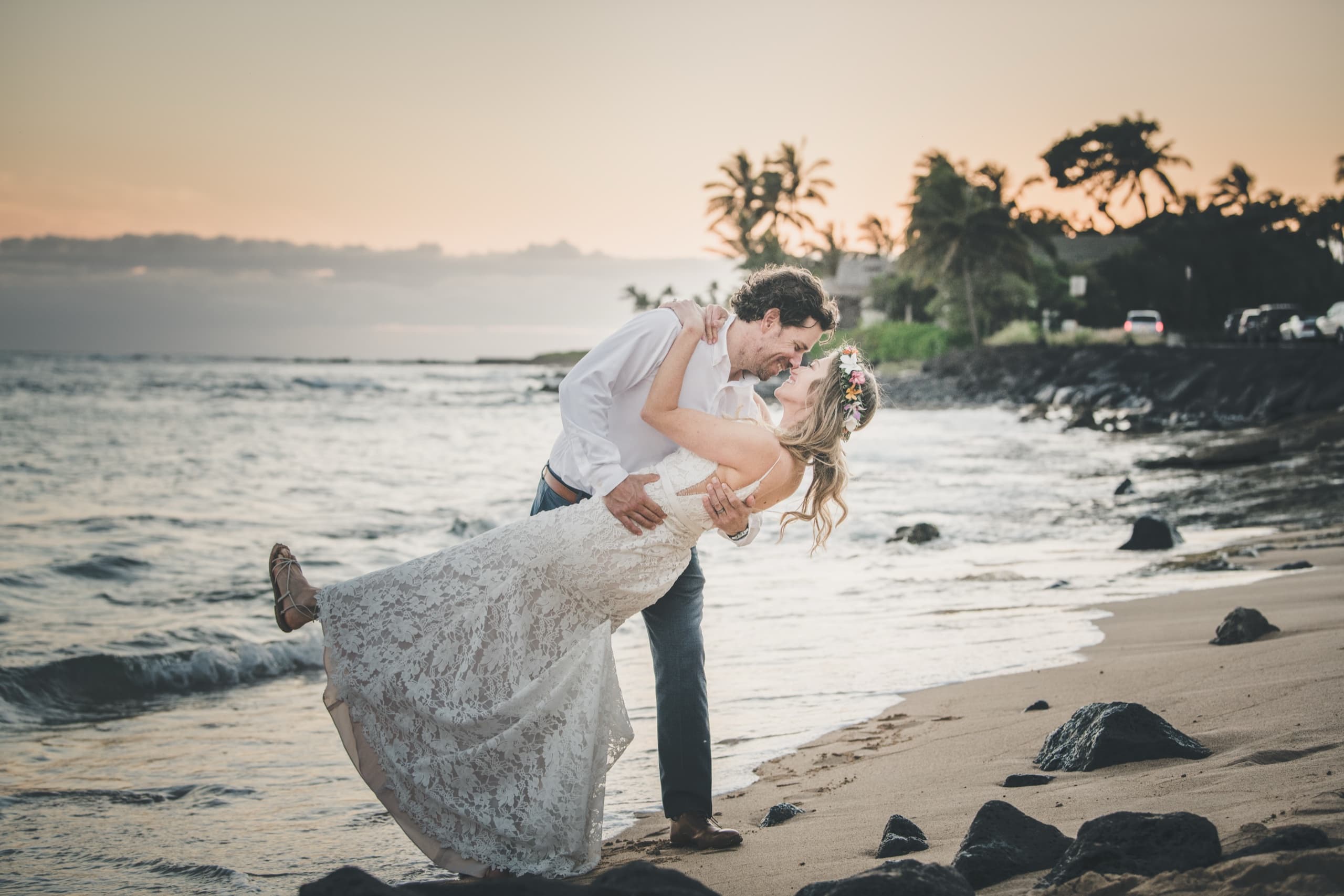 Kenny dips Erin at the water's edge as the sun sets behind the palms on Kauai's south shore