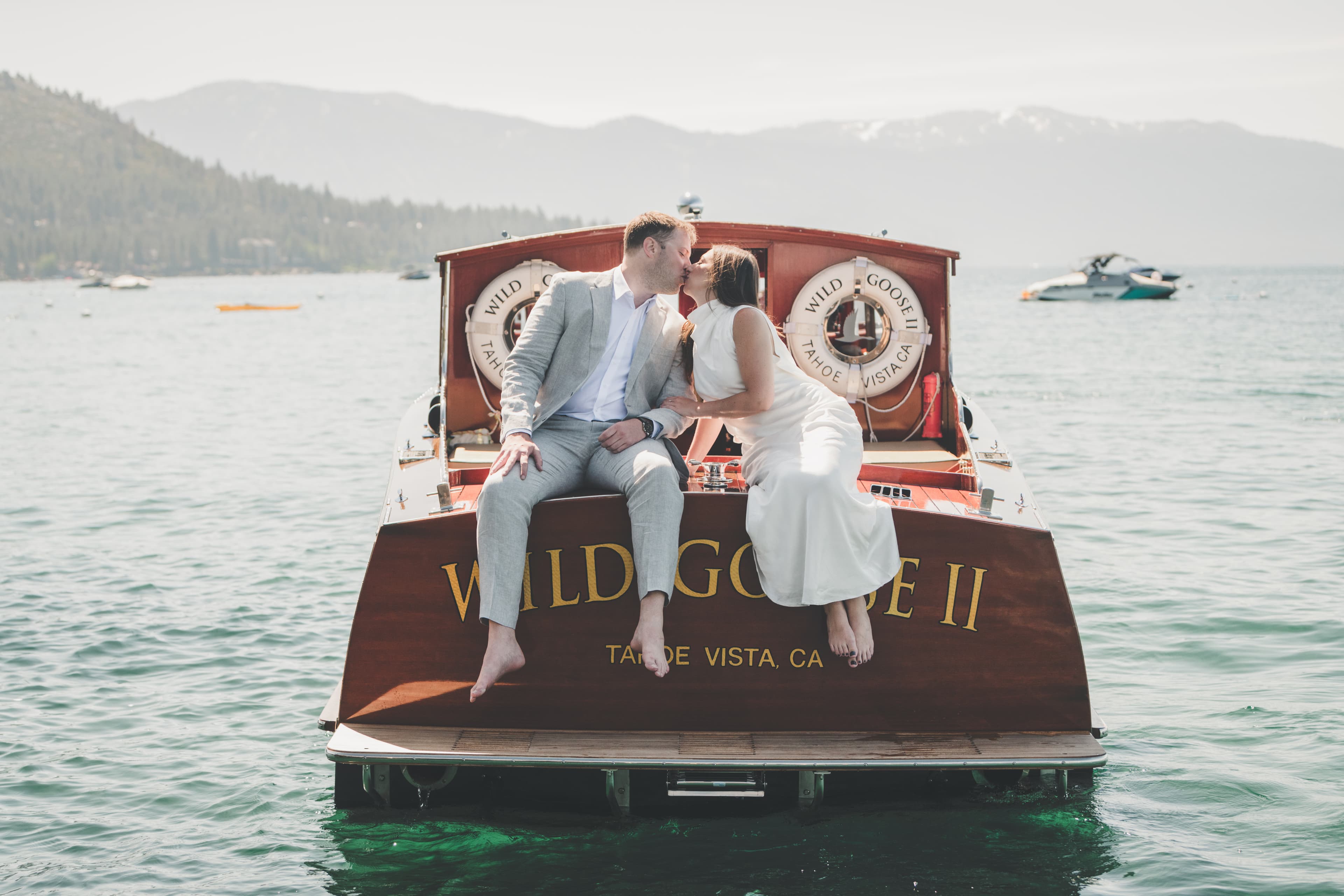 Hannah and Will kissing on the stern of the wooden boat Wild Goose II during their first look on Lake Tahoe