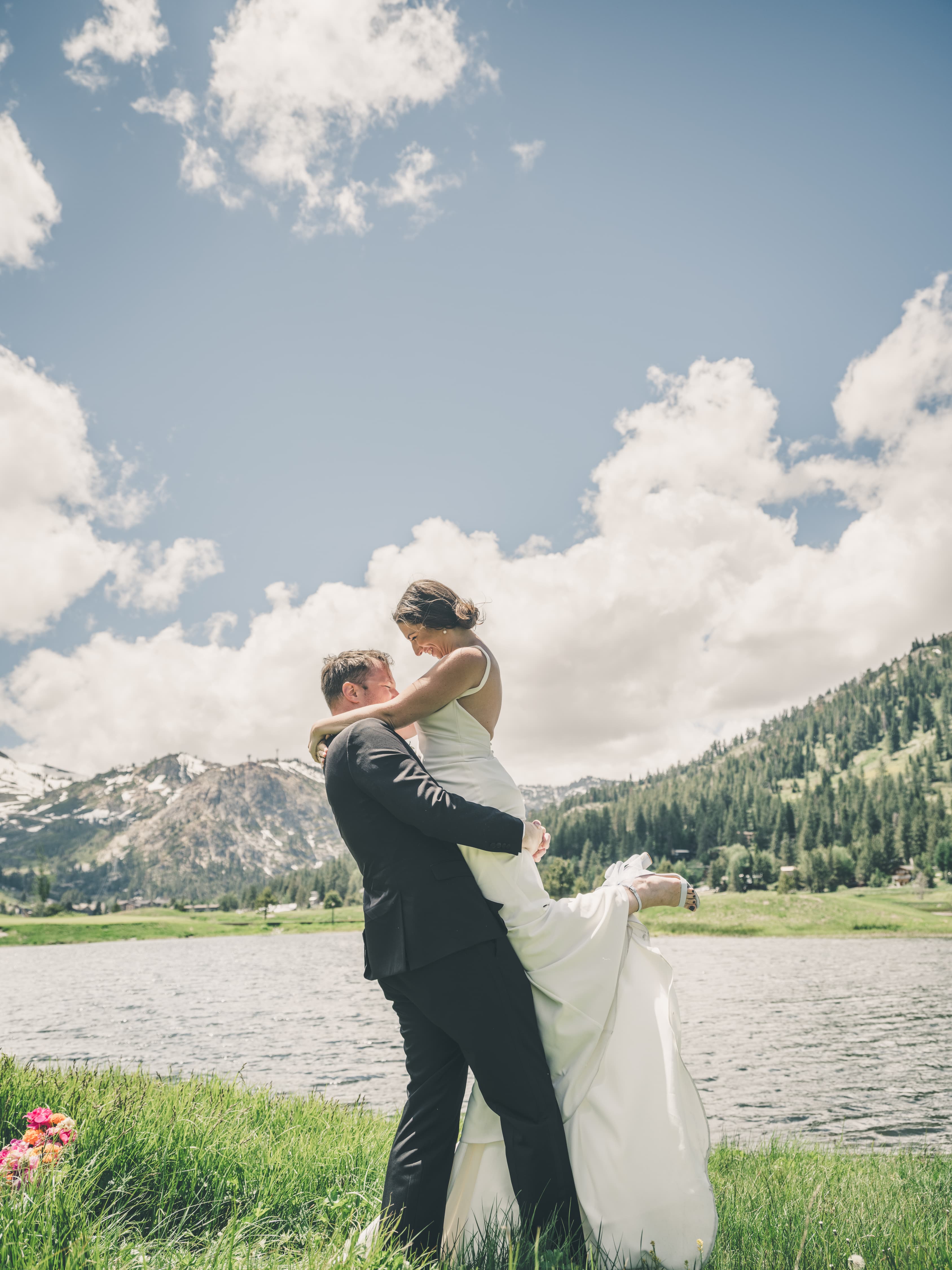 Will lifting Hannah at the edge of a Sierra lake with snow patches still on the ridges behind