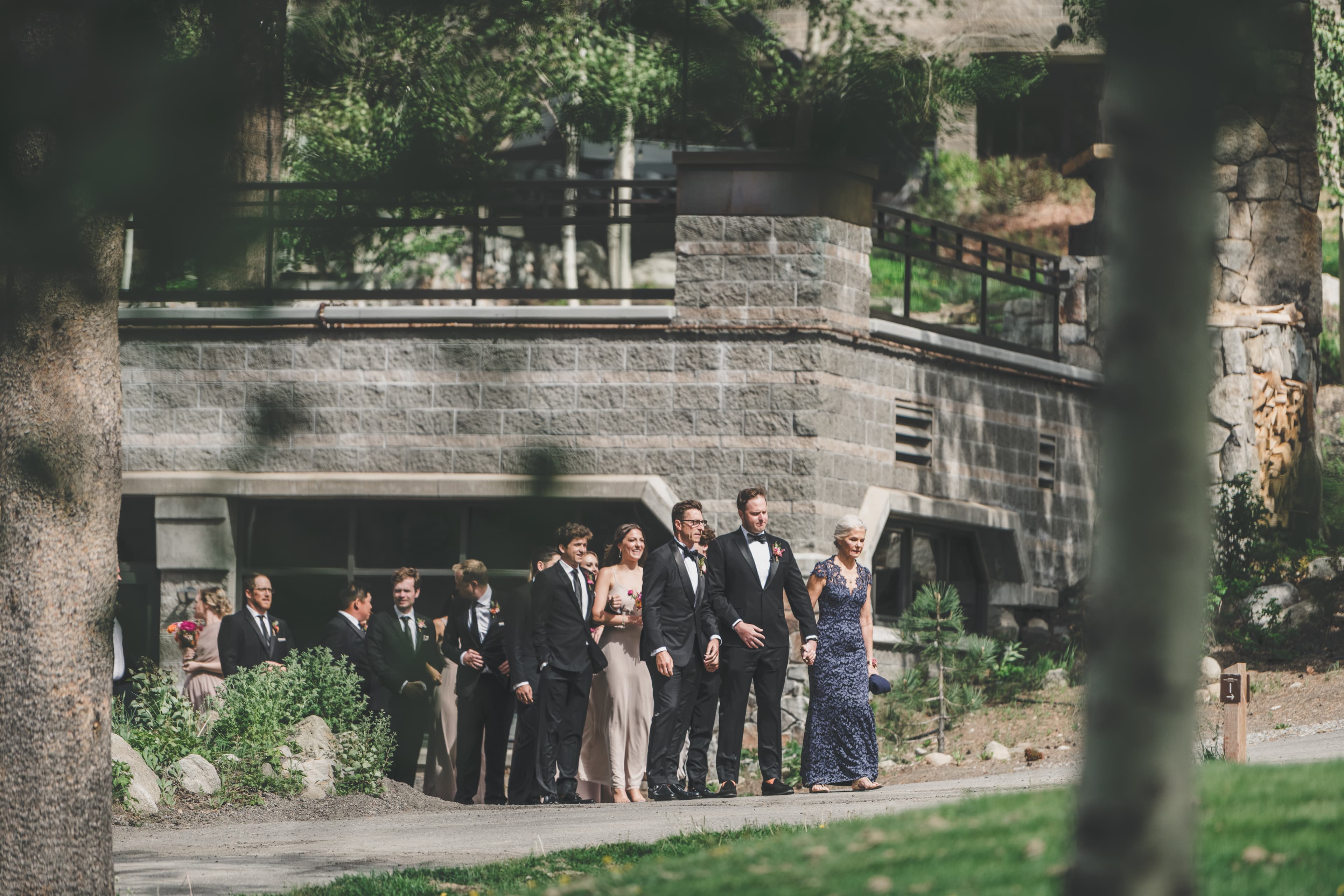 Hannah and Will leading the bridal party along the stone path of Everline Resort toward the ceremony lawn