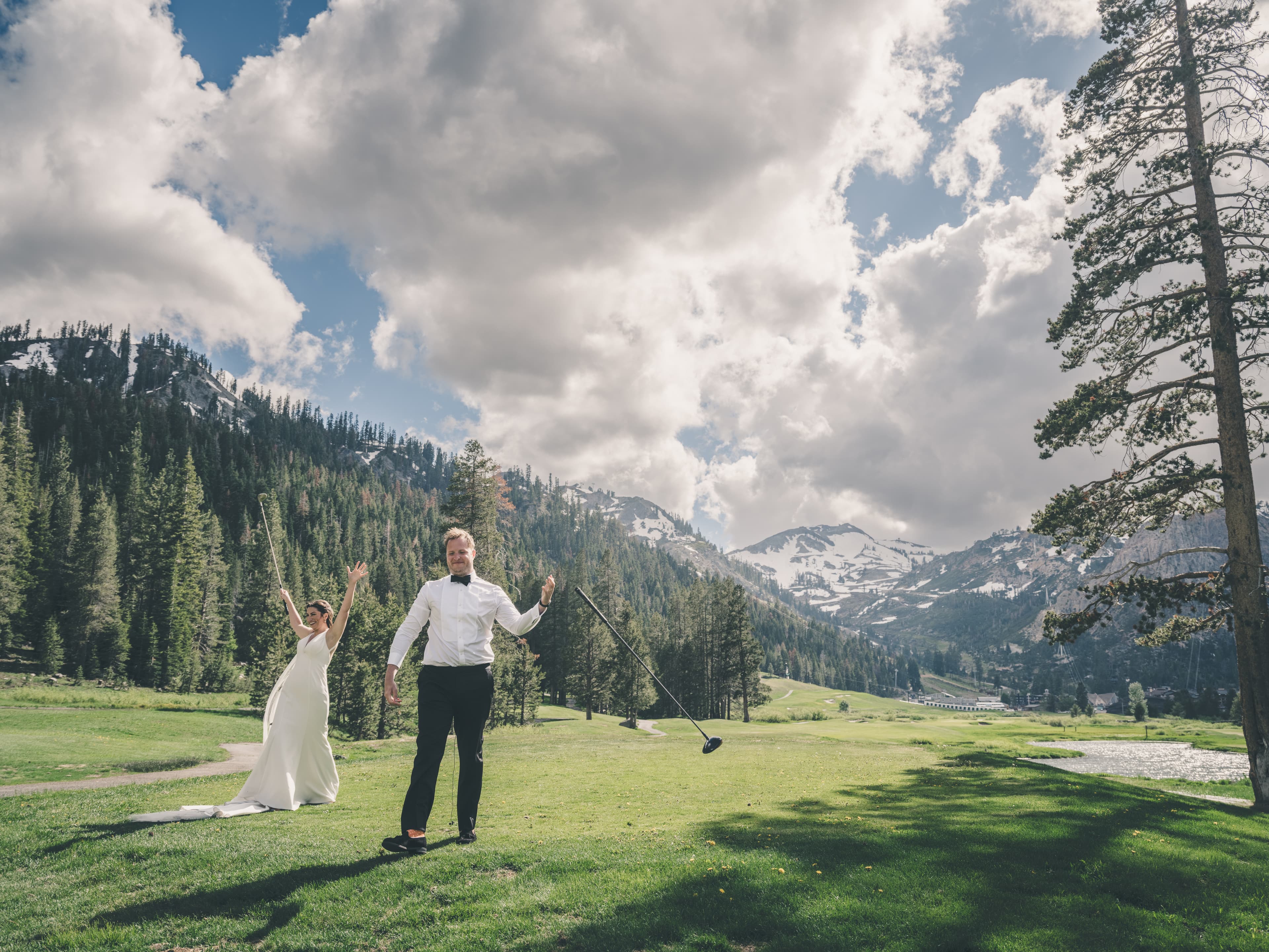 Hannah and Will celebrating with golf clubs raised on the Everline fairway after the ceremony