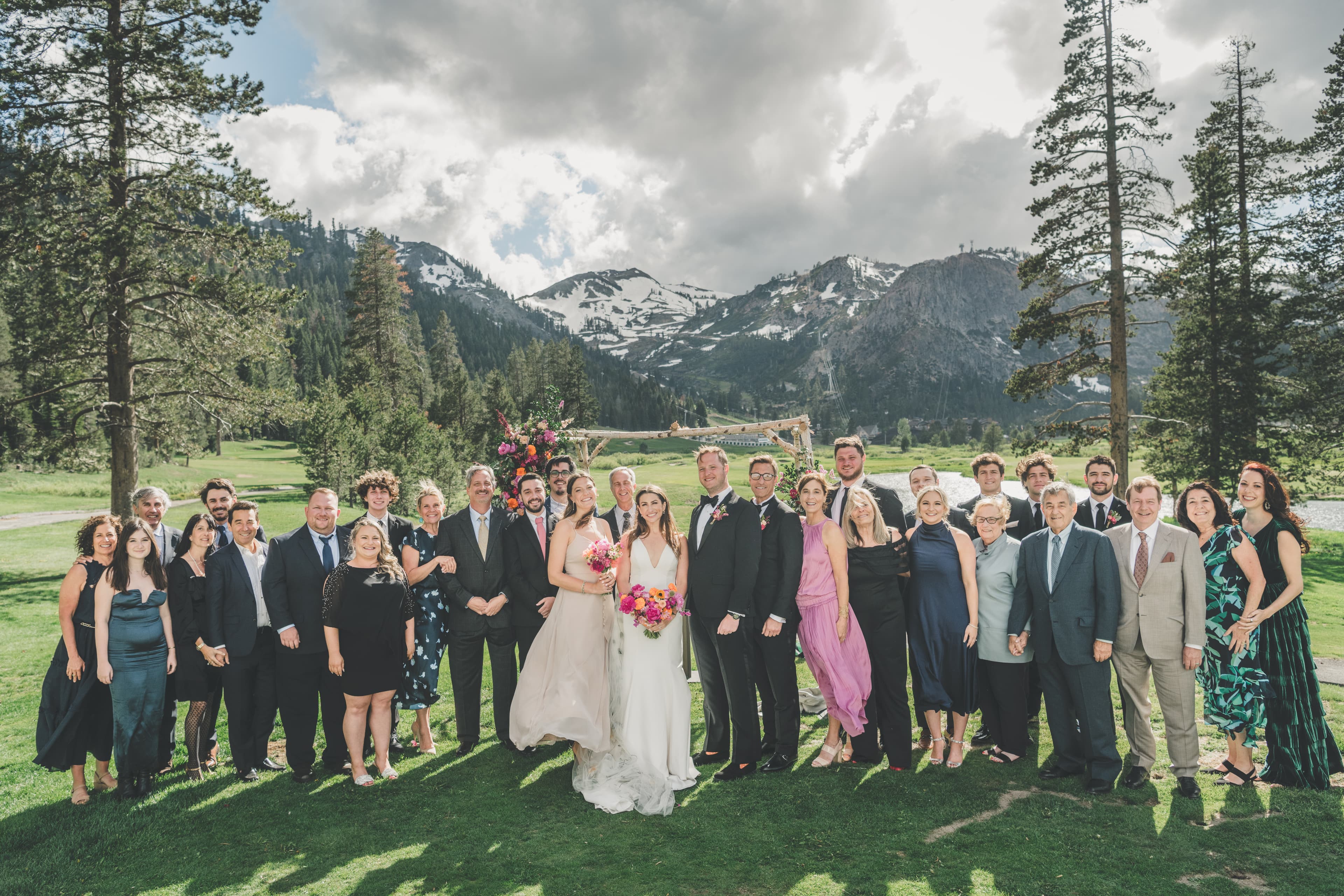 Full family and friends portrait at Everline Resort with Hannah and Will at center and the Sierra peaks behind