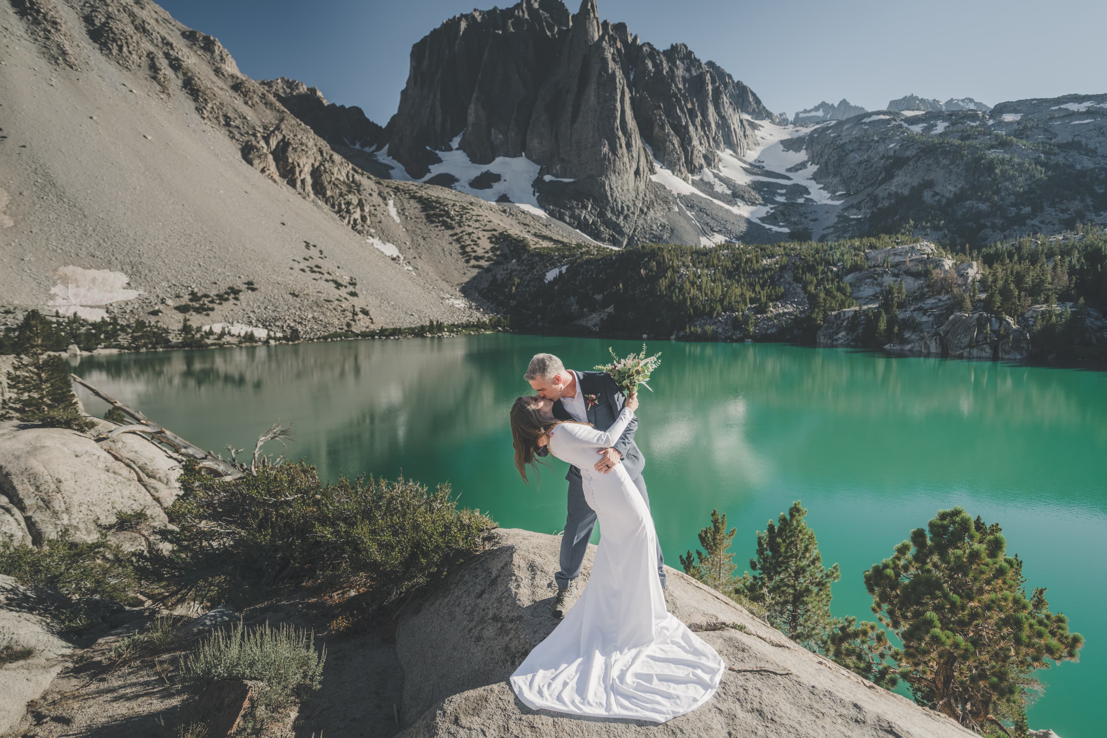 Chrishna and Scott Mammoth elopement — couple embracing with alpine lake scenery