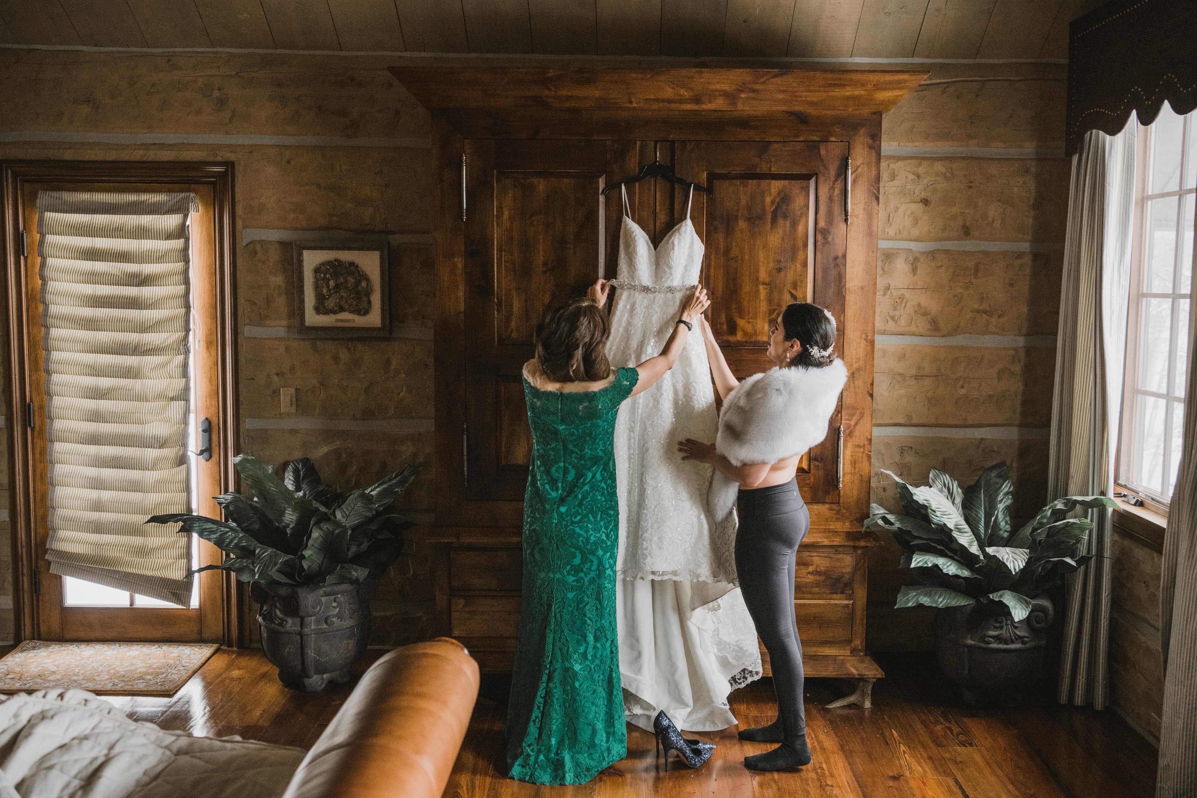 Sabrina's wedding dress hanging on the armoire as she and her sister get it ready
