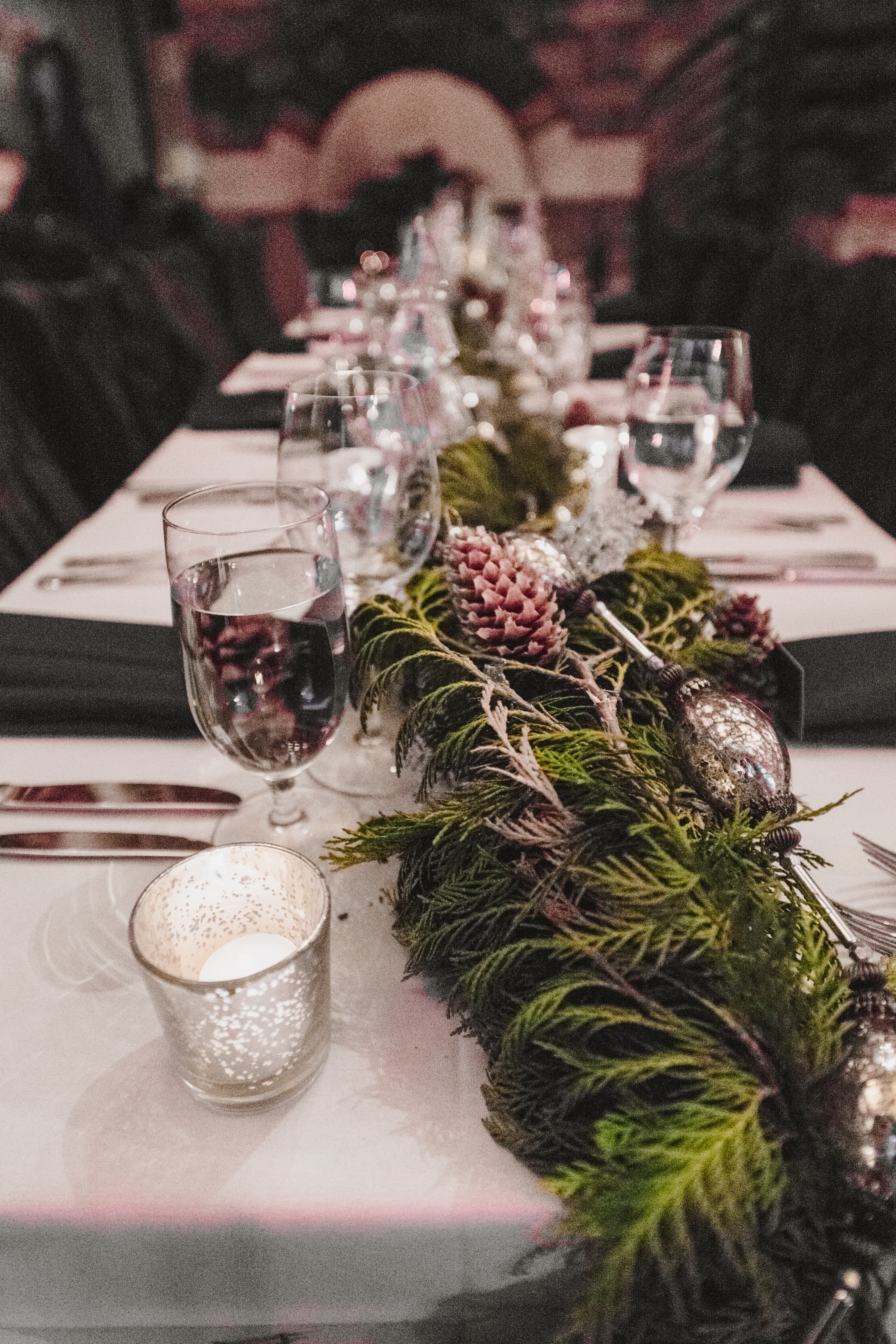 Reception table detail — wine glasses, candles and cedar garland with pinecones at Alpino Vino
