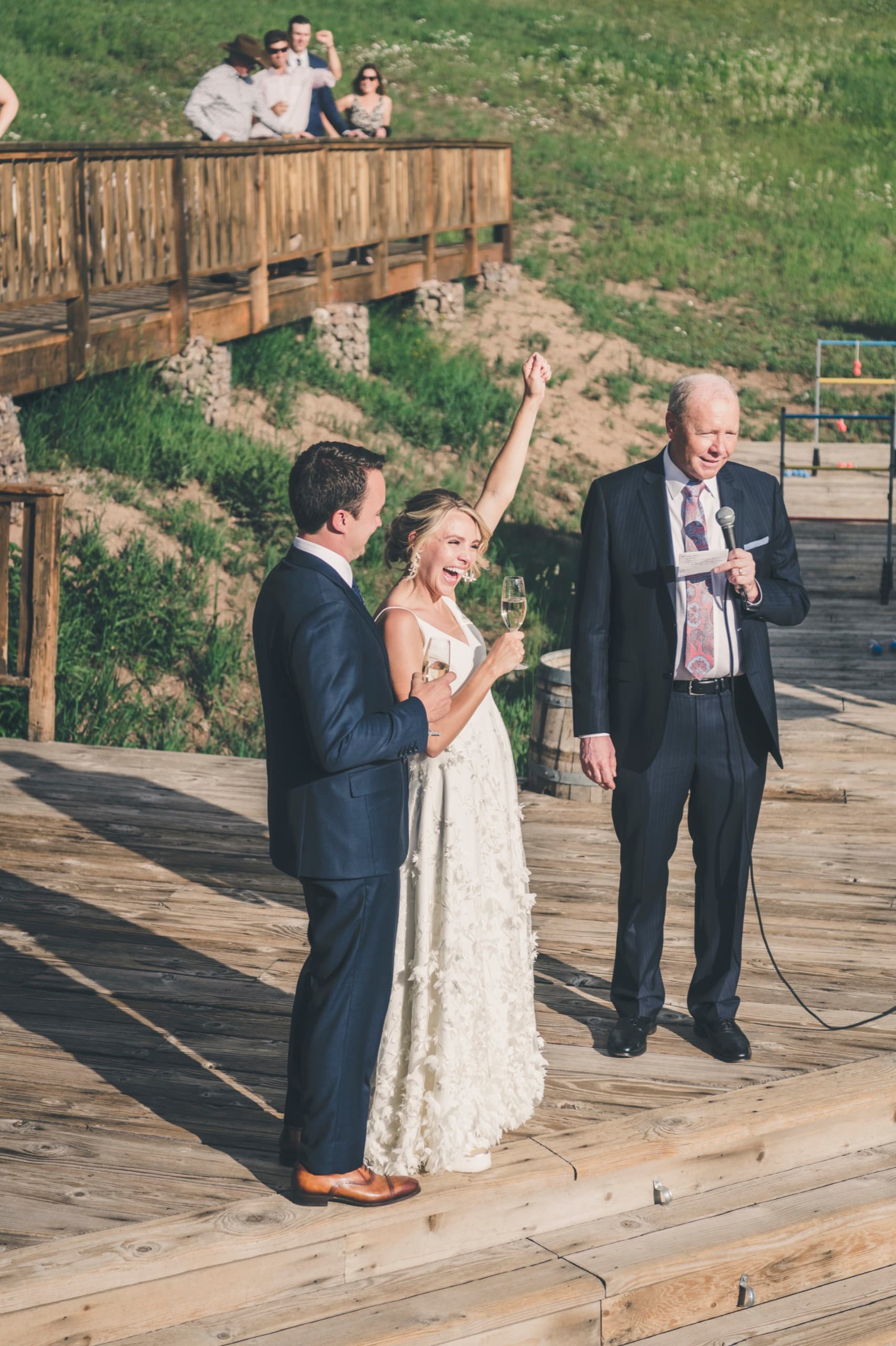 Meghan mid-cheer with arm raised celebrating during the deck toast at Gorrono Ranch
