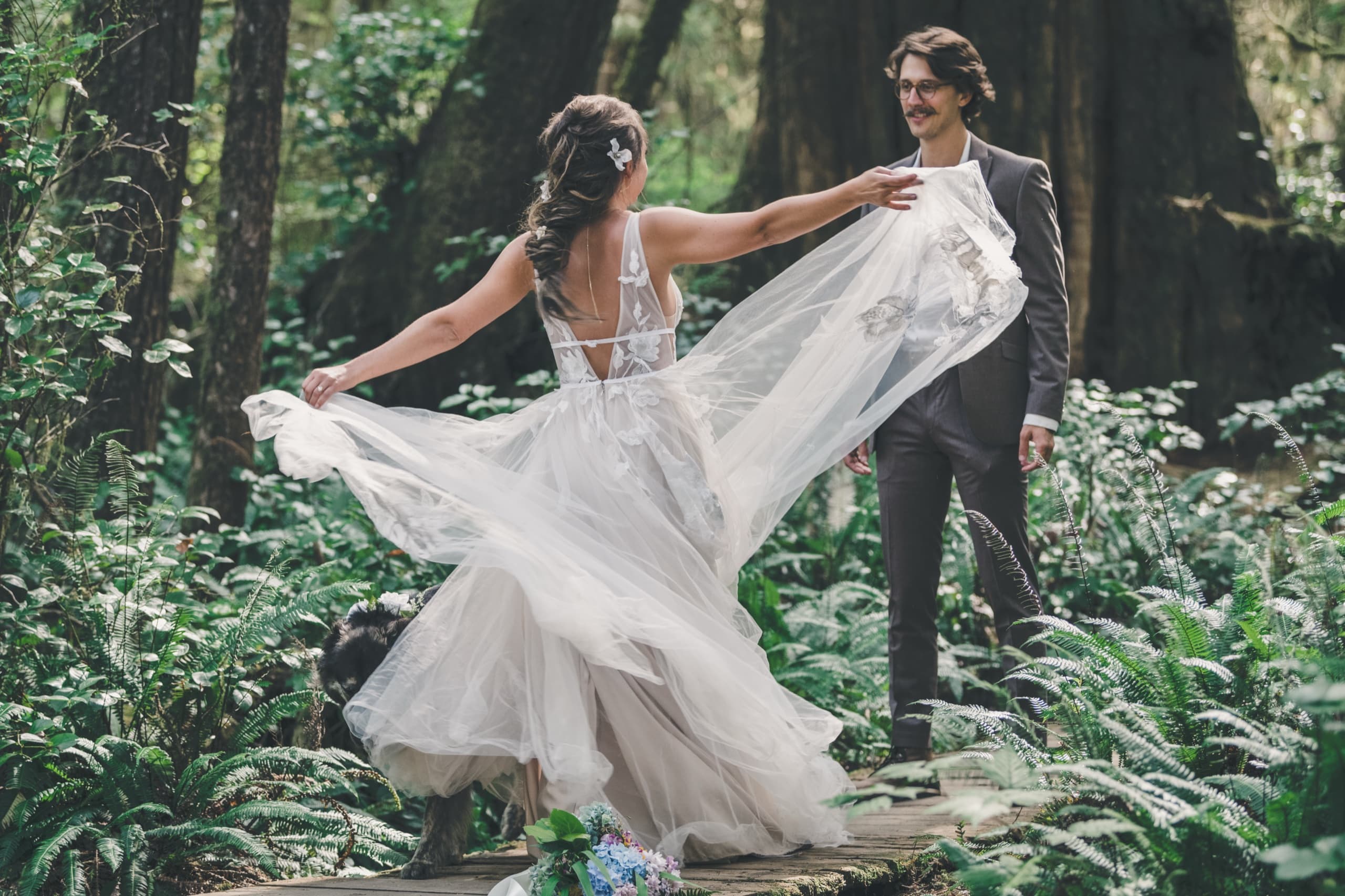 Rachel twirling her tulle dress with Peter in a fern-filled Vancouver Island forest