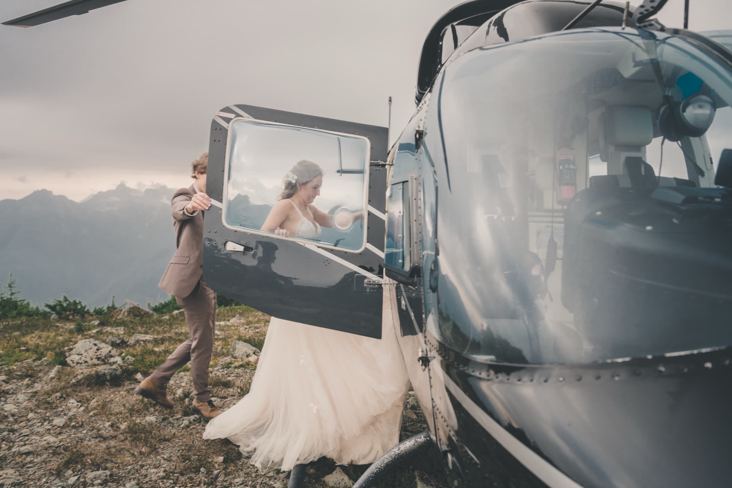 Peter helping Rachel into the helicopter door, profile through the window