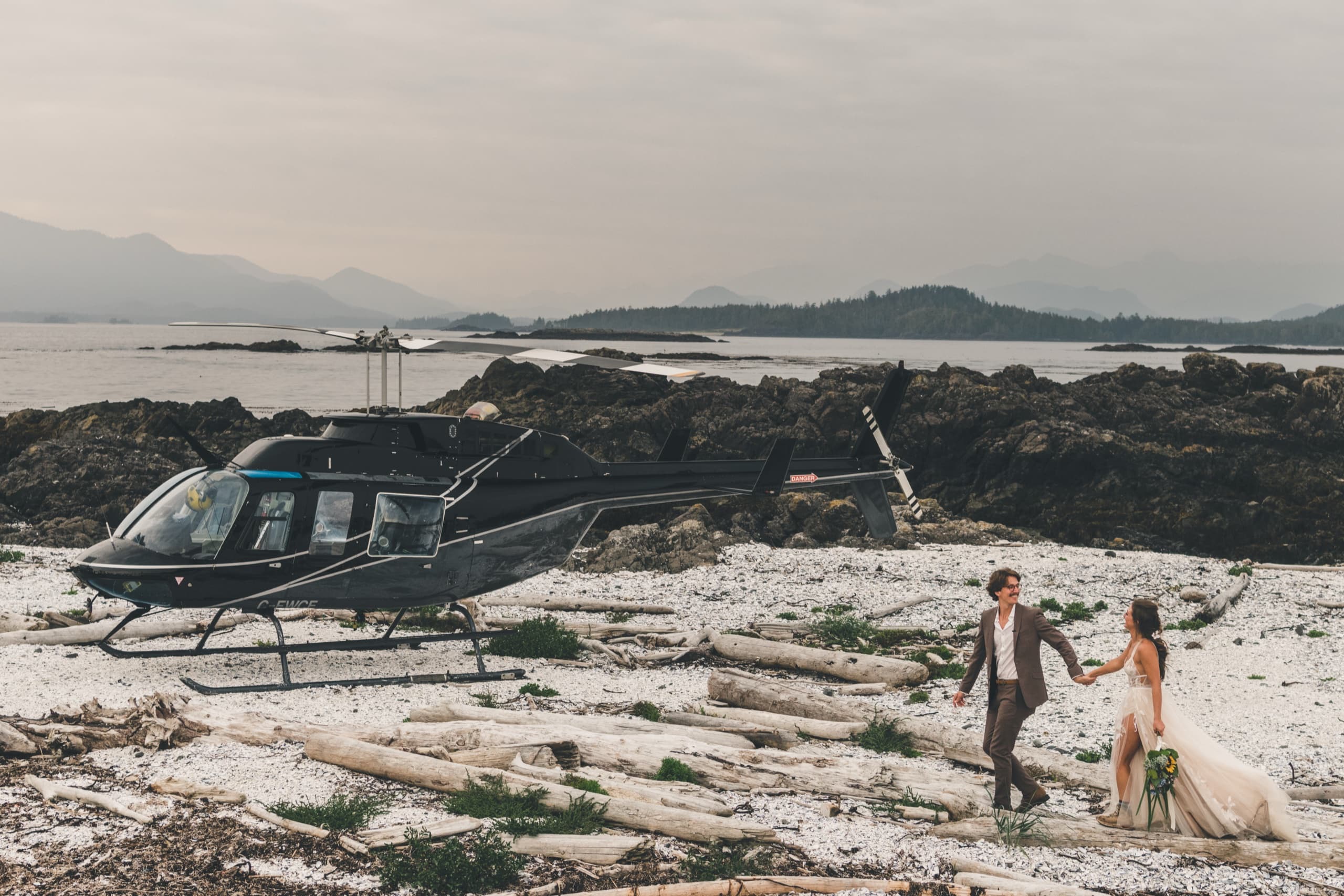 The helicopter on a remote driftwood beach with Rachel and Peter walking hand in hand