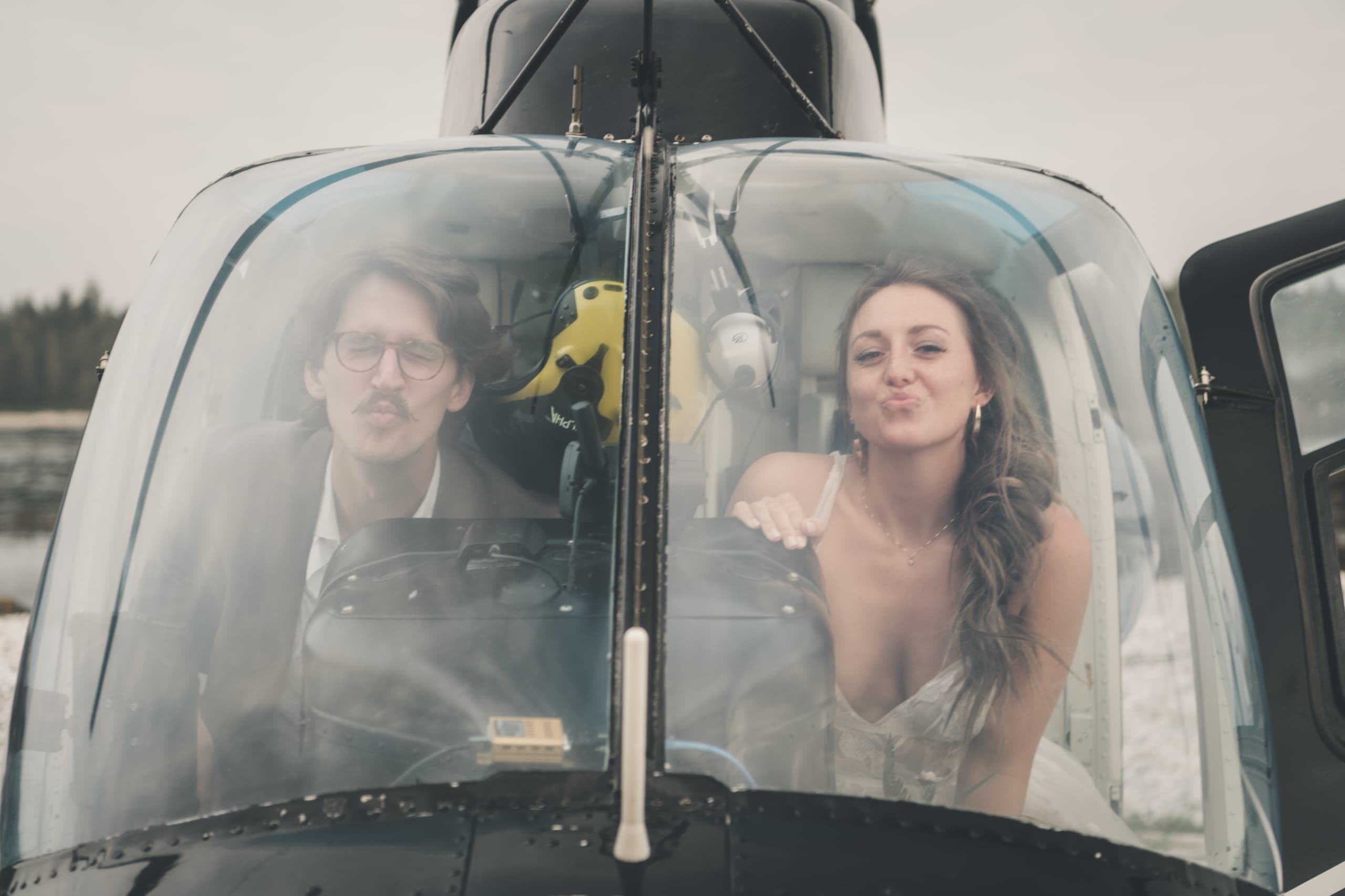 Playful through-the-windscreen portrait of Rachel and Peter making faces inside the cockpit