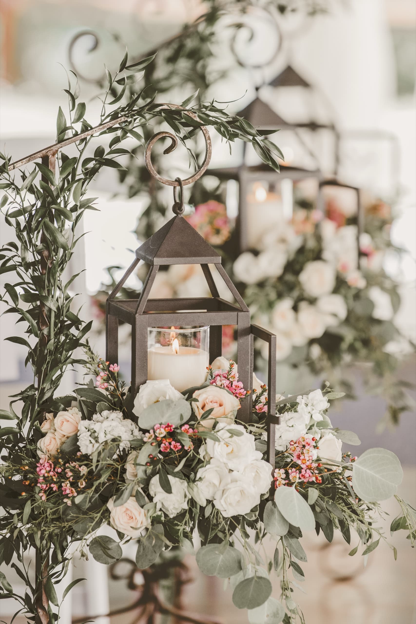 Lantern centerpiece with greenery garland and roses on the ceremony table at Tenaya Lodge