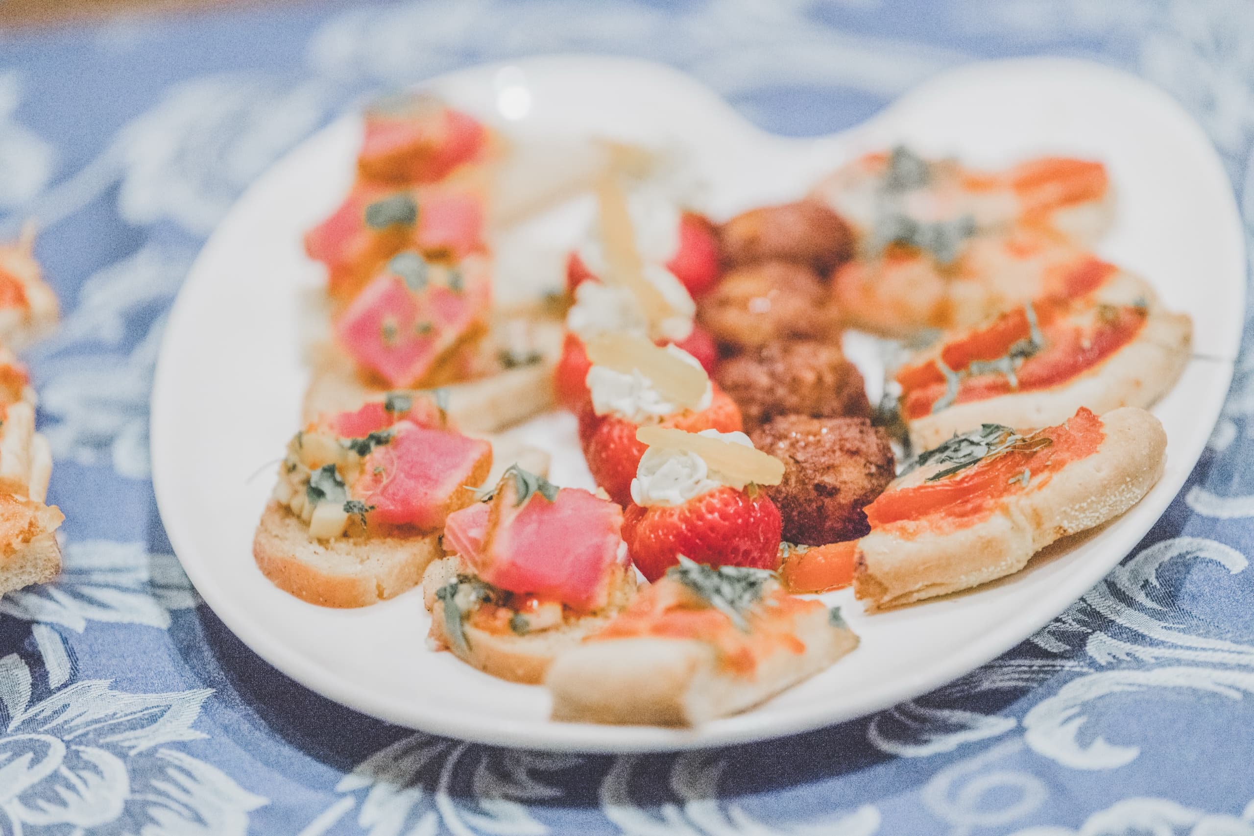 Plate of bruschetta appetizers on patterned linen at Jolly and Billy's reception