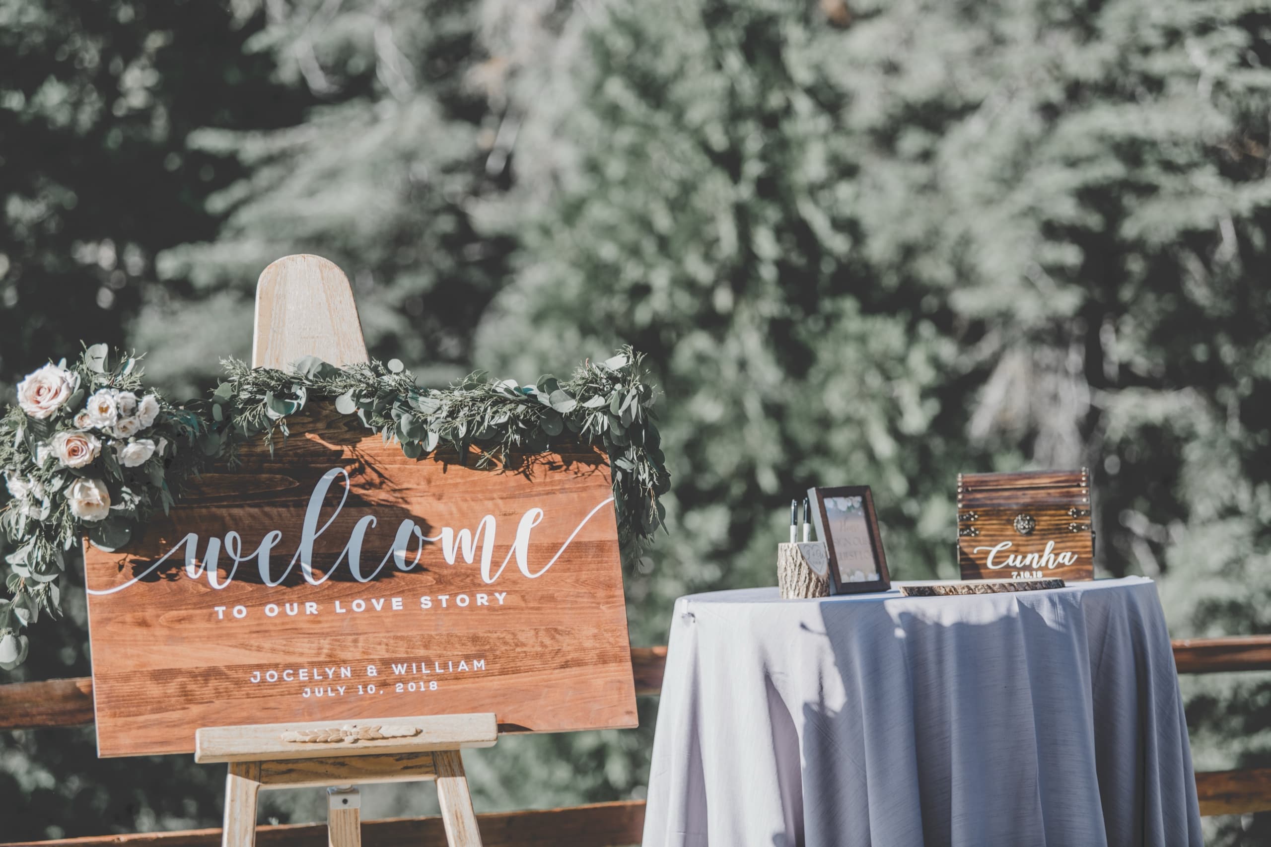 Welcome to our love story — Jolly and Billy wood sign with the pine forest backdrop at Tenaya Lodge