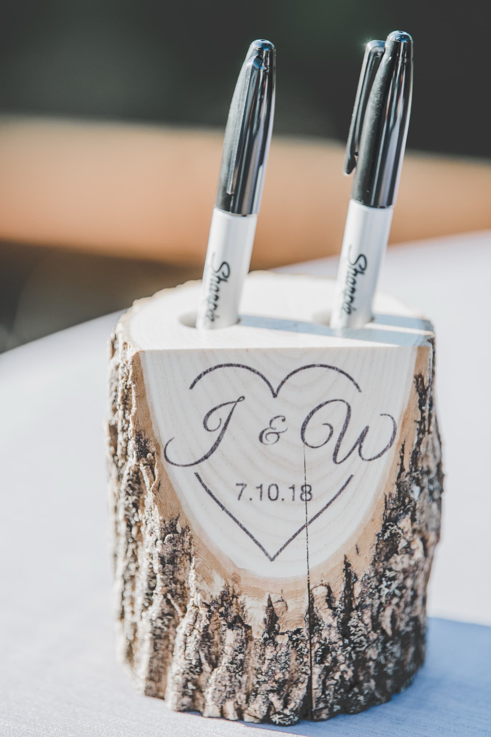 Wood-slab guest book pen holder engraved with Jolly and Billy's wedding date detail