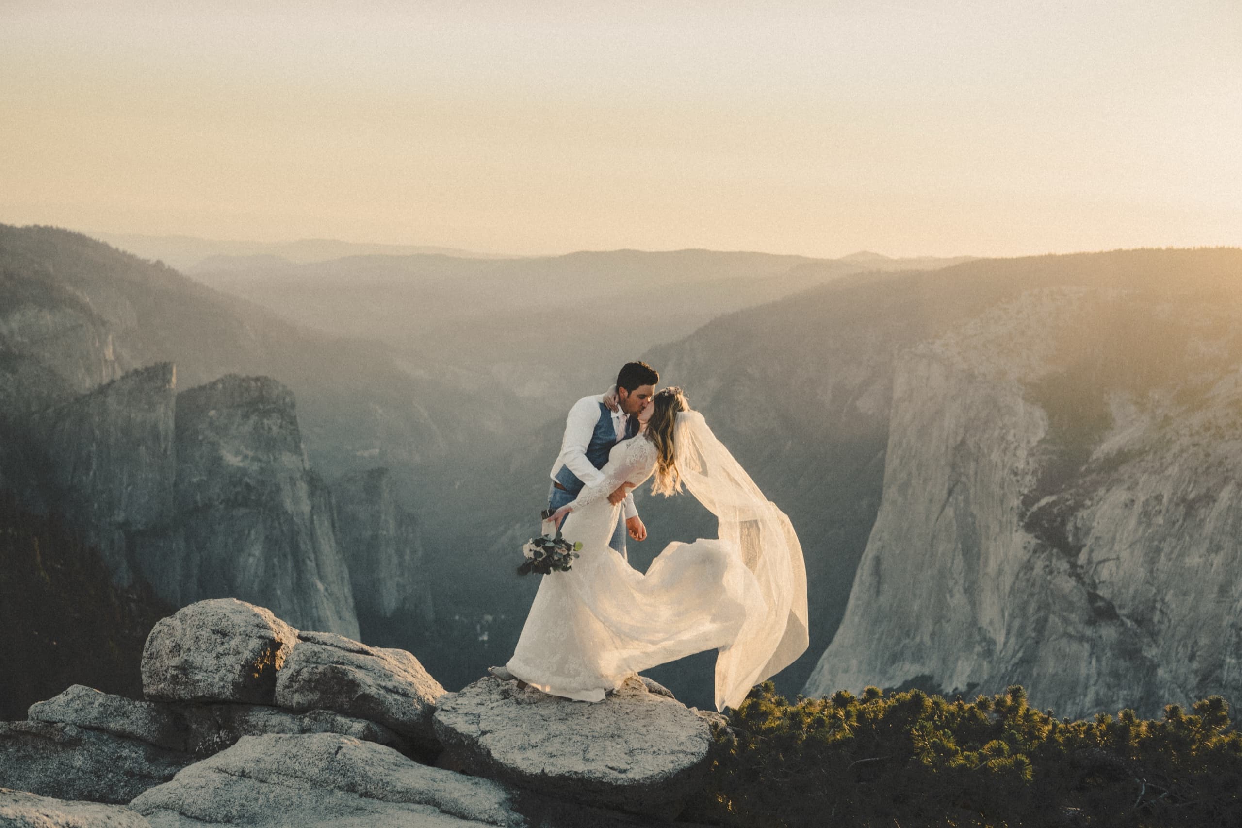 Jolly and Billy share a kiss on the cliff edge at Taft Point as Yosemite Valley glows at golden hour