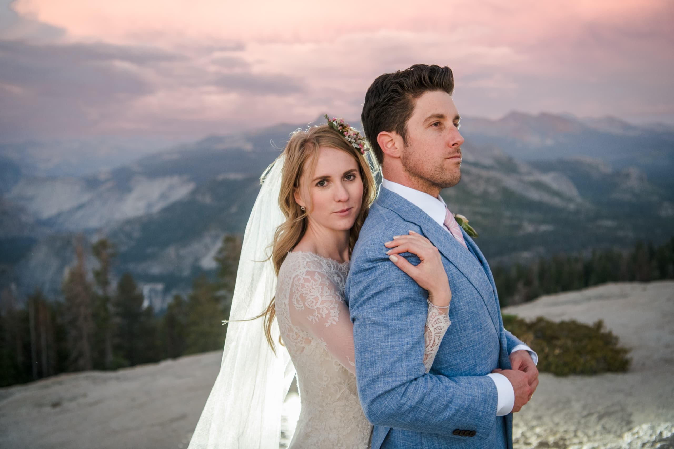 Jolly leaning on Billy's shoulder, pastel sky and Sierra ridges behind them