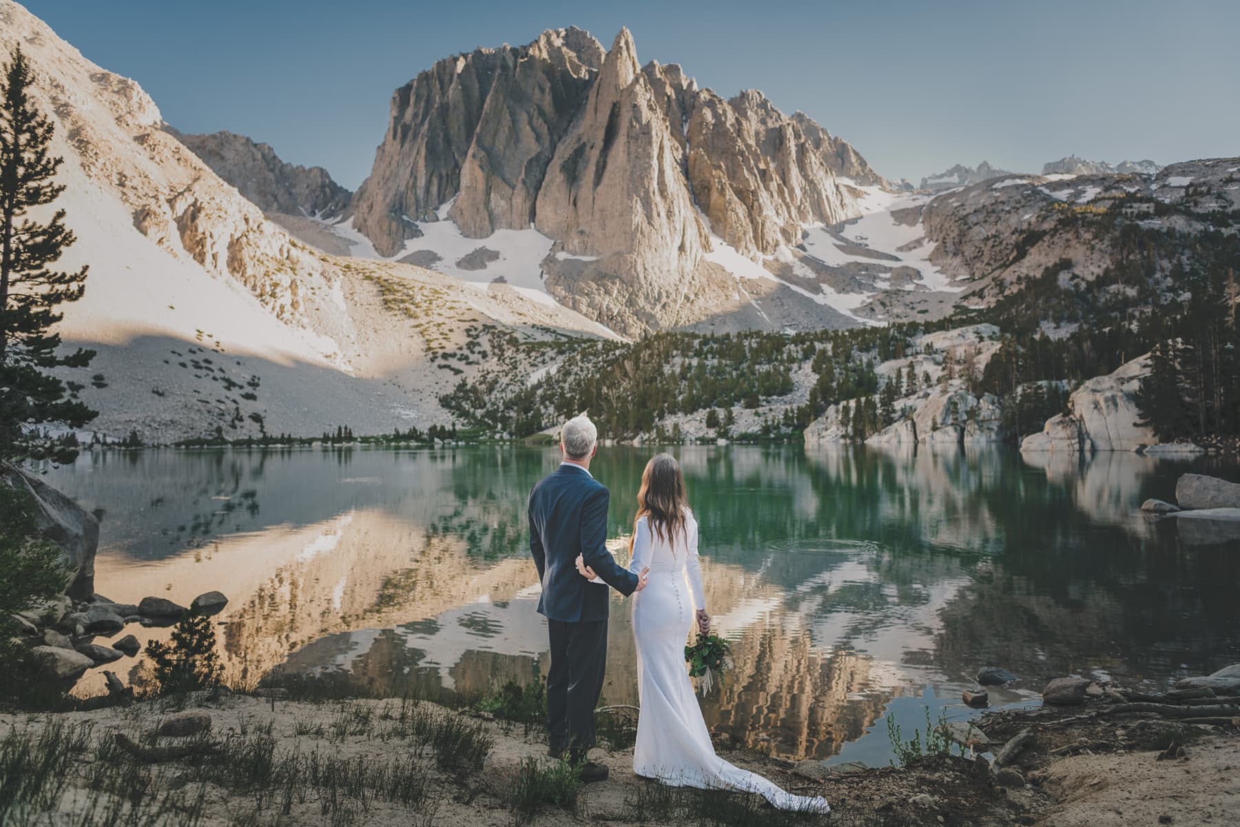 Wedding couple at dramatic mountain ceremony venue at golden hour